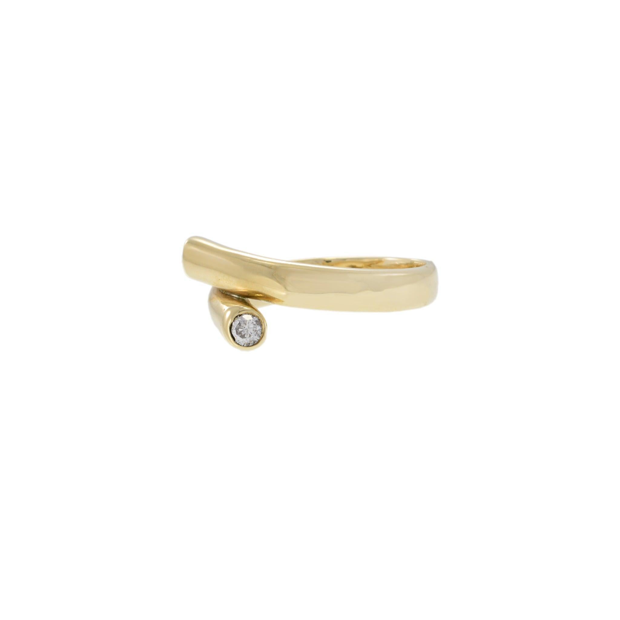 Sleek and sculptural, this vintage wrap ring in 14KT yellow gold features a modern bypass design finished with two bezel-set round diamonds totaling 0.20 carats. Its fluid silhouette hugs the finger with a subtle twist, offering understated elegance