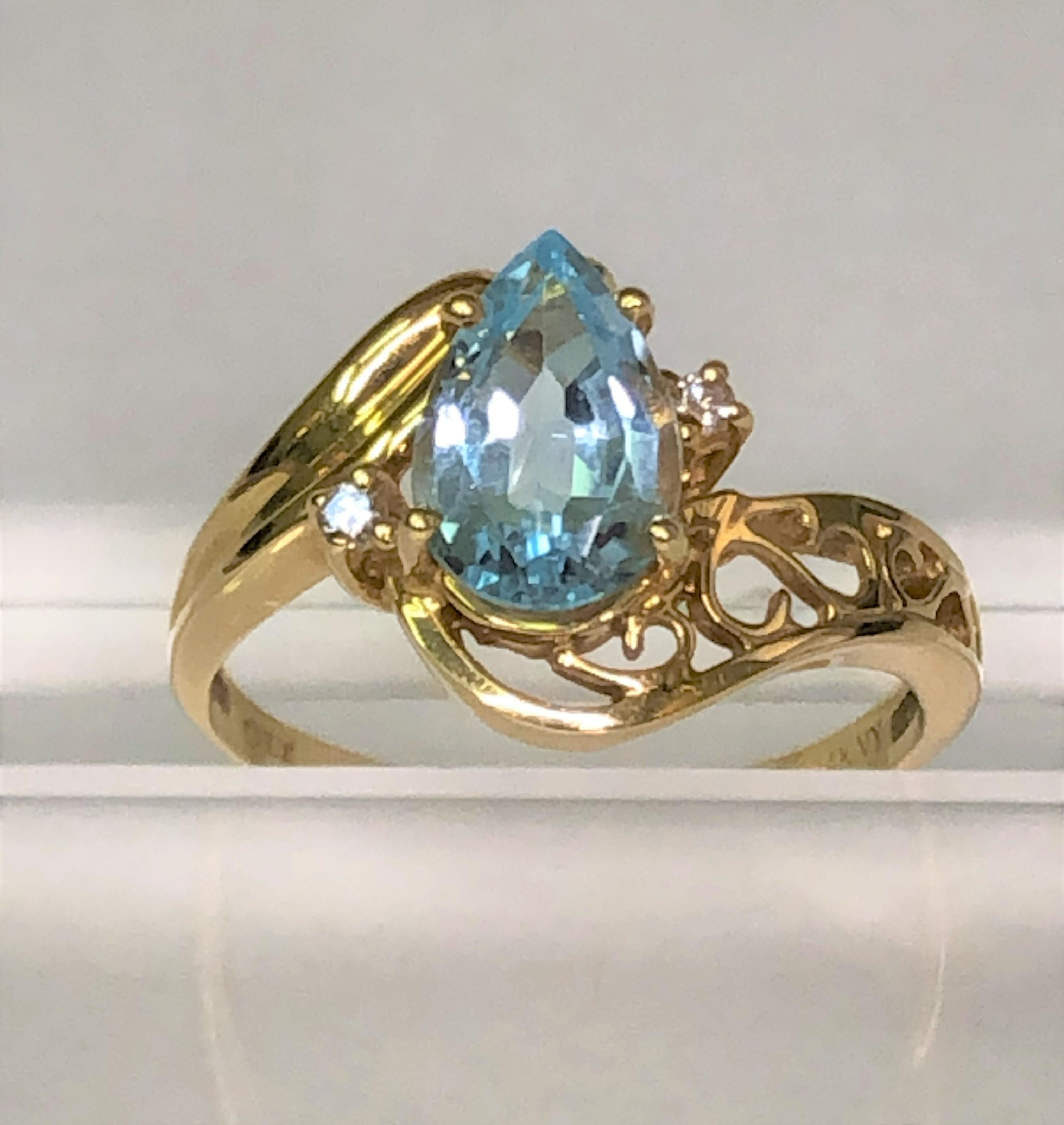 This classic ring will be great for anyone!  
14 karat yellow gold decorative mounting with pear cut blue topaz and two round diamonds.
Beautiful prong set pear shaped blue topaz.  Approximately 9mm x 6mm.
Two prong set round diamonds. 