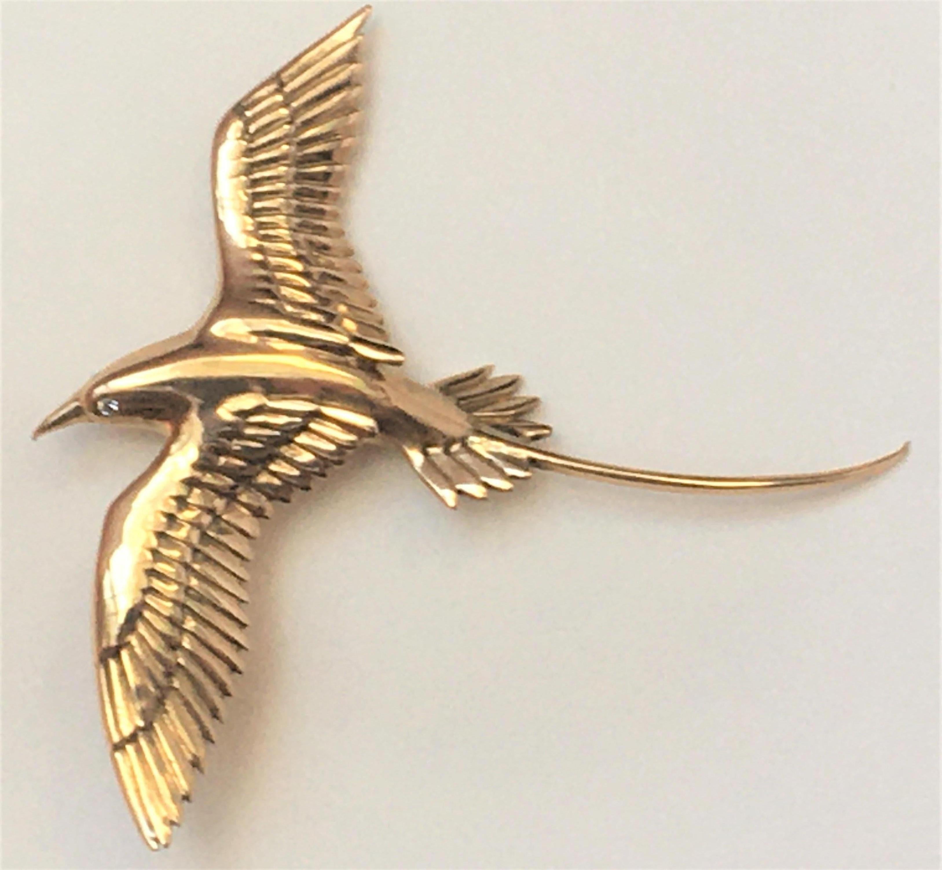 This gorgeous bird will be the highlight of any outfit!
14 karat yellow gold bird in flight with long tail
2 small round diamonds for eyes
Brooch is approximately 2.375 inches (beak to tail)  X 2.375 inches (wing span)
Hinged pin with safety  