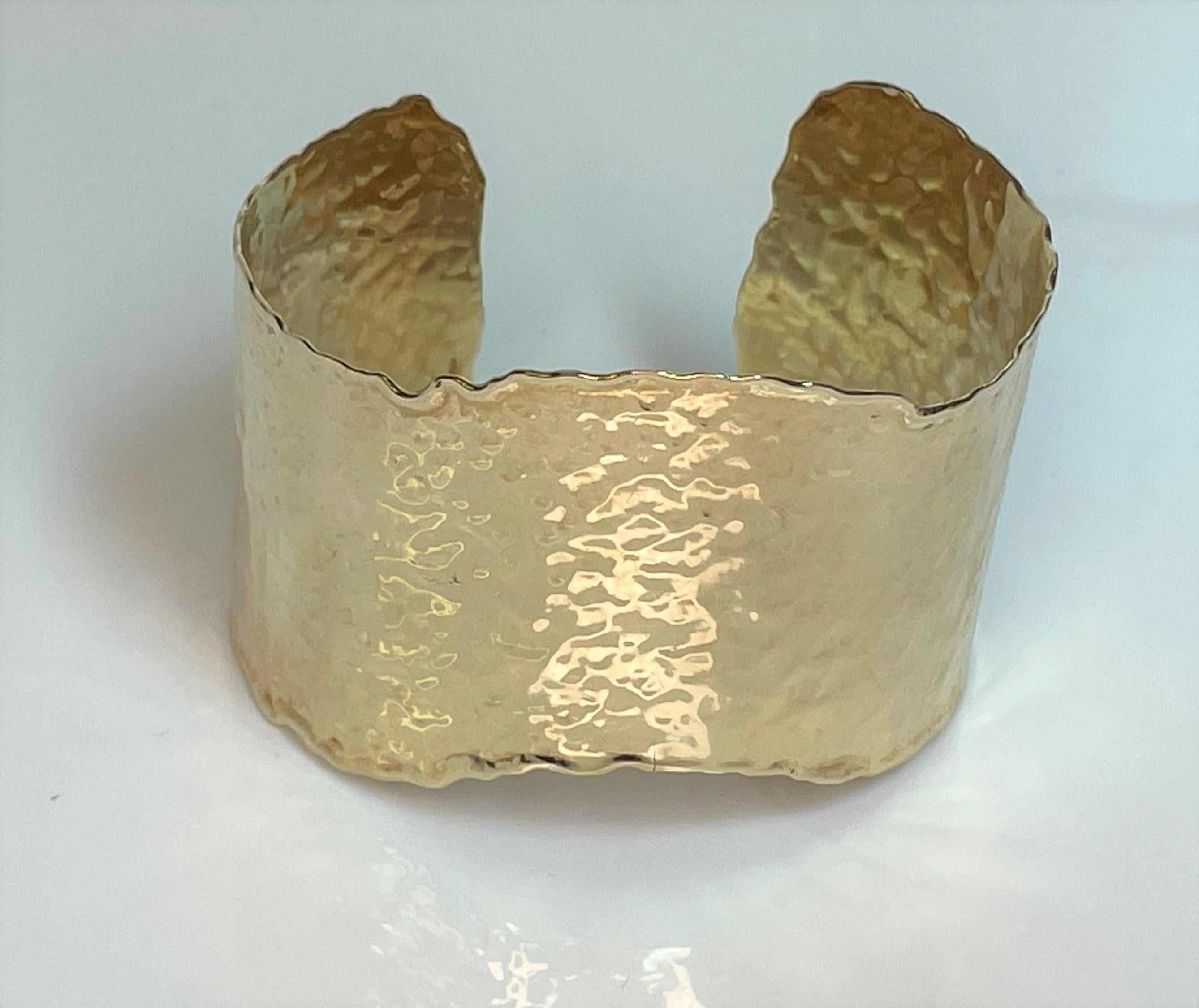 This unique curved style bracelet is sure to grab attention and is an easy to wear everyday piece.
14 karat hammered yellow gold finish.
Scallop curved design.
Approximately 37mm wide.
