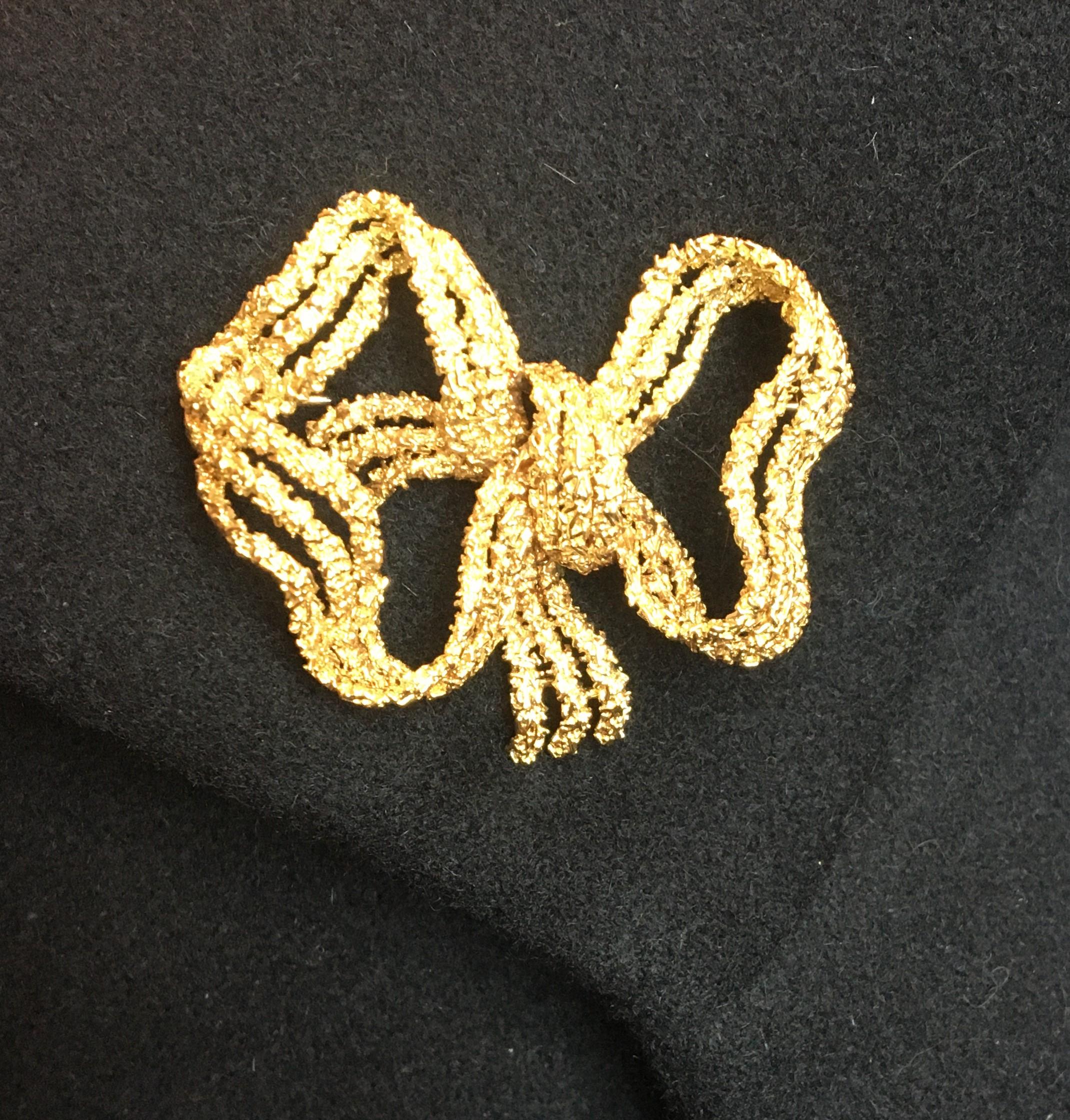 This beautiful brooch will look great on any piece of clothing.
14 karat yellow gold 
Three strands with textured finish 
Straight pin closure with C clasp