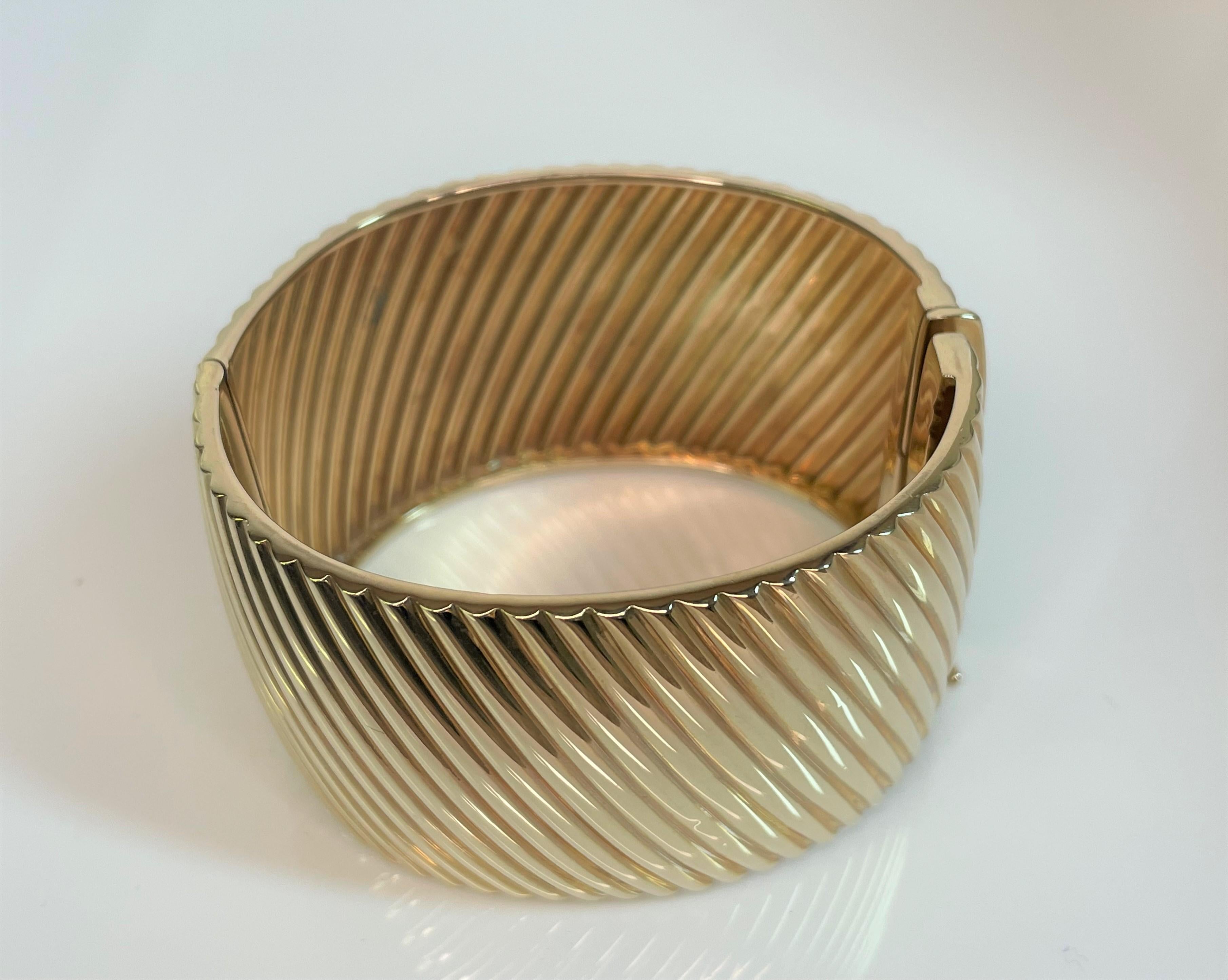 This is a great, easy to wear, everyday bracelet!
14 karat yellow gold ribbed design.
Hinged with hidden box closure with safety.
Approximately 39mm wide.
Approximately 7.25 inches inside circumference at smallest point (outside