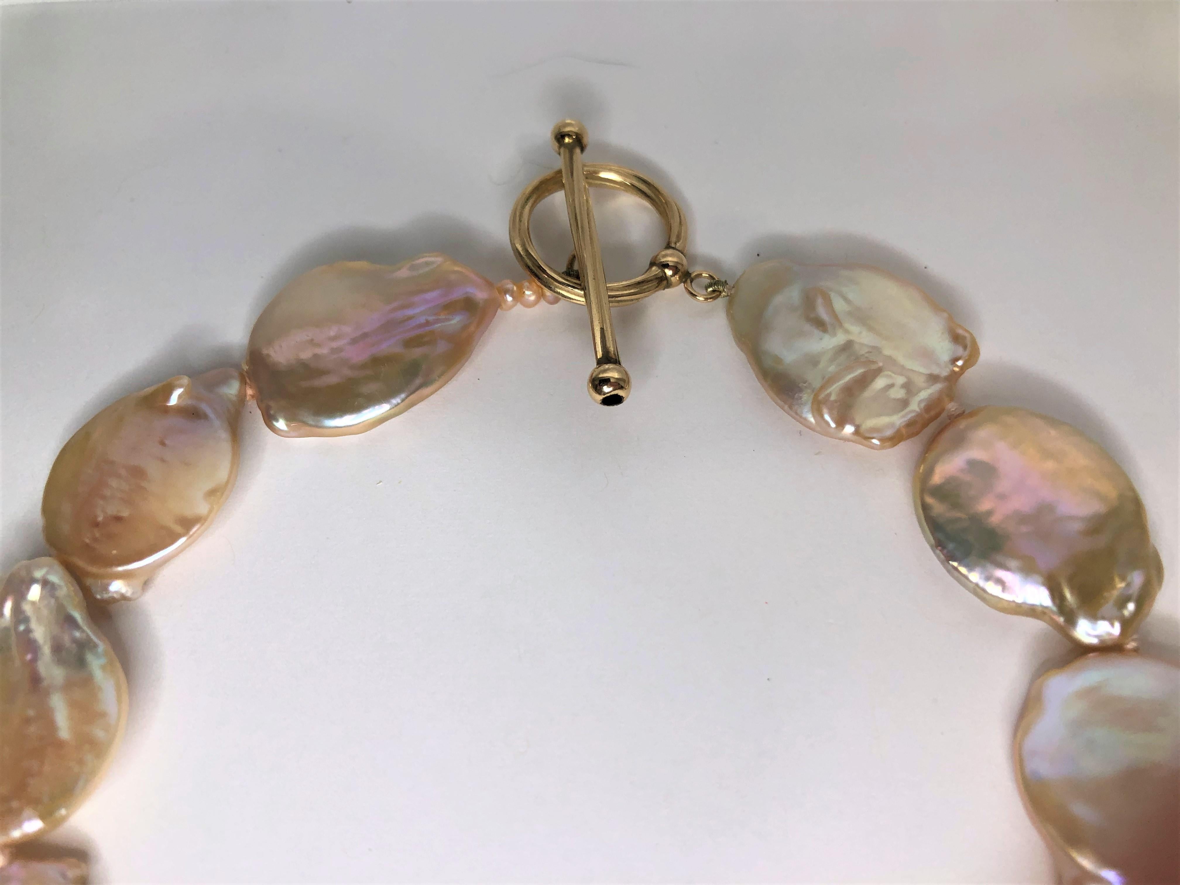 This beautiful pearl necklace is an easy to wear and is a  beautiful peach/pink color!
Large coin pearl knotted necklace with gold color toggle clasp. z
Toggle clasp has slightly twisted design.
18 shiny, baroque coin pearls varying in size and