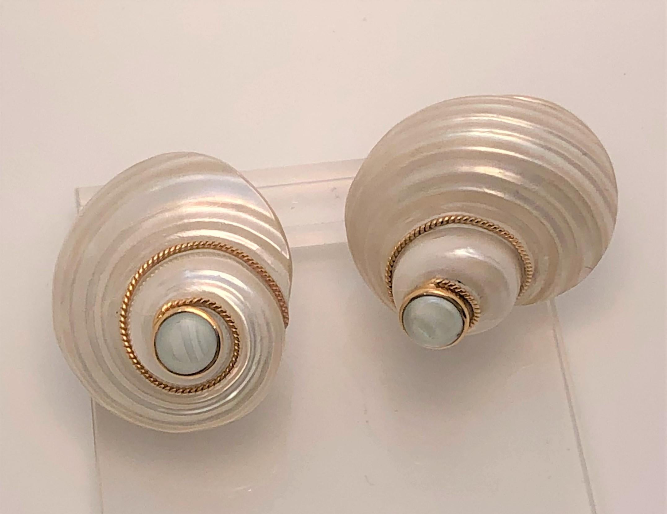 These earrings make a statement and will look beautiful with any outfit!  Wear them at the beach or anywhere.
14 karat yellow gold post and lever back.
2 shells with 14ky twist complements the natural lines of the creamy white shells
Two bezel set