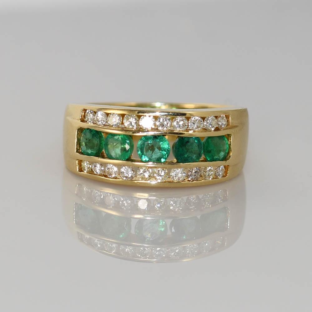 Emerald and diamond band in 14k yellow gold.
Stamped 14k, 585 and weighs 6.2 grams.
The natural emeralds are round brilliant cuts, approximately .75 total carats, excellent color.
The diamonds on the sides are round brilliant cuts, .50 total carats,