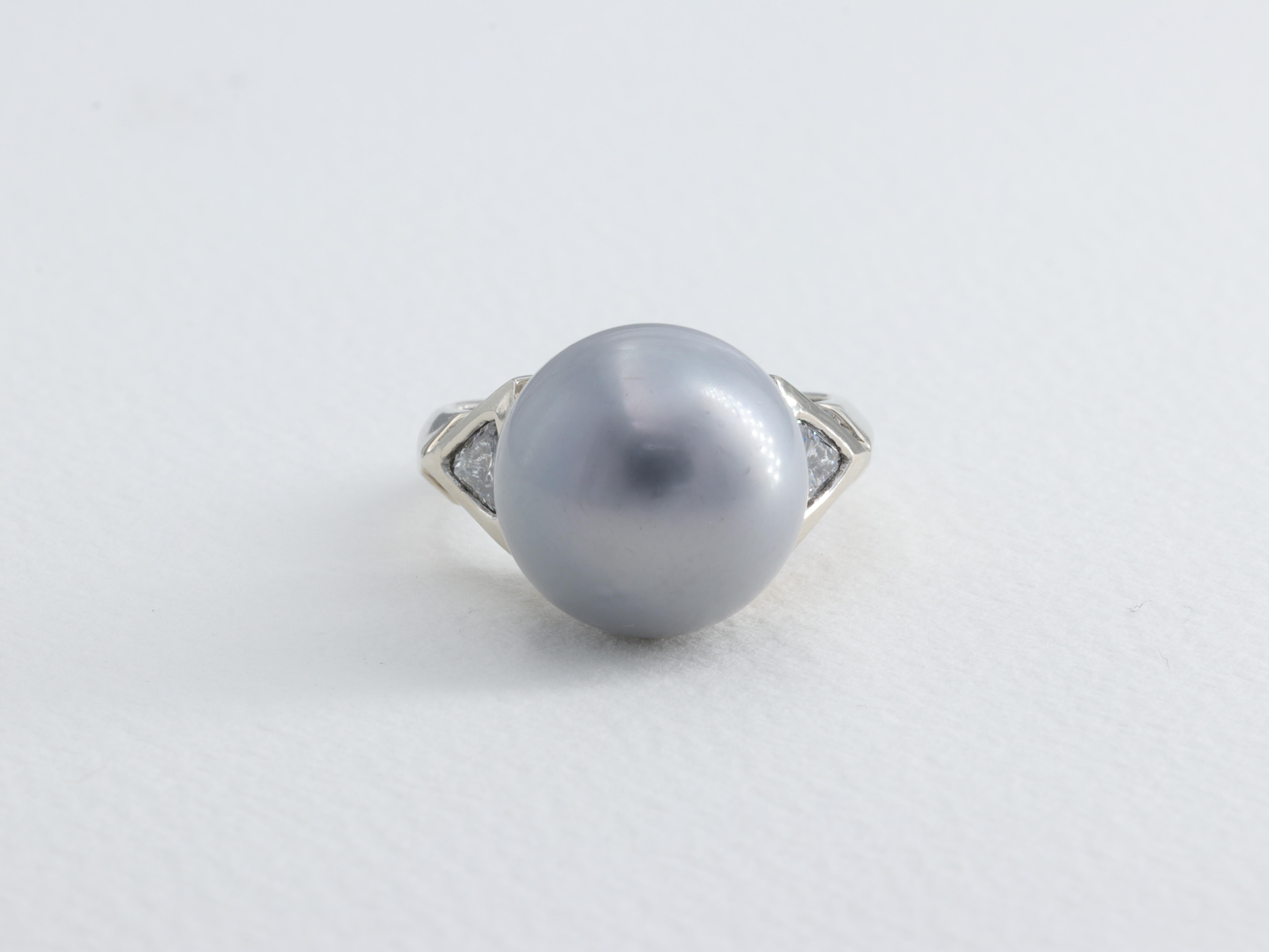 14 MM Silver Tahitian Pearl and Trillion Diamond 3 Stone Ring in 14 Karat White Gold

Pearl:

Measurement - 14mm 
Color - Silver Grey 
Quality - Very Good Minimal Blemishes 

Diamonds:

Weight - Approximately 0.80 carats
Color - G-H
Clarity - SI1-