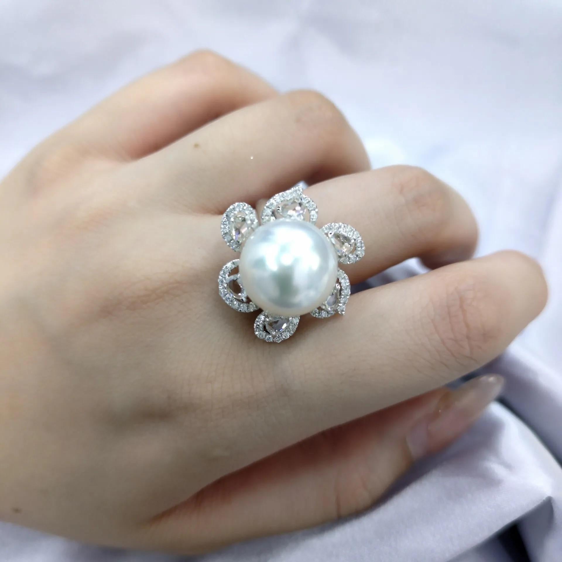 This exquisite ring features a magnificent South Sea pearl as its centerpiece. The pearl, measuring an impressive 14mm in diameter, is a testament to nature's artistry. It is set in a delicate floral design, with the pearl resembling the center of a