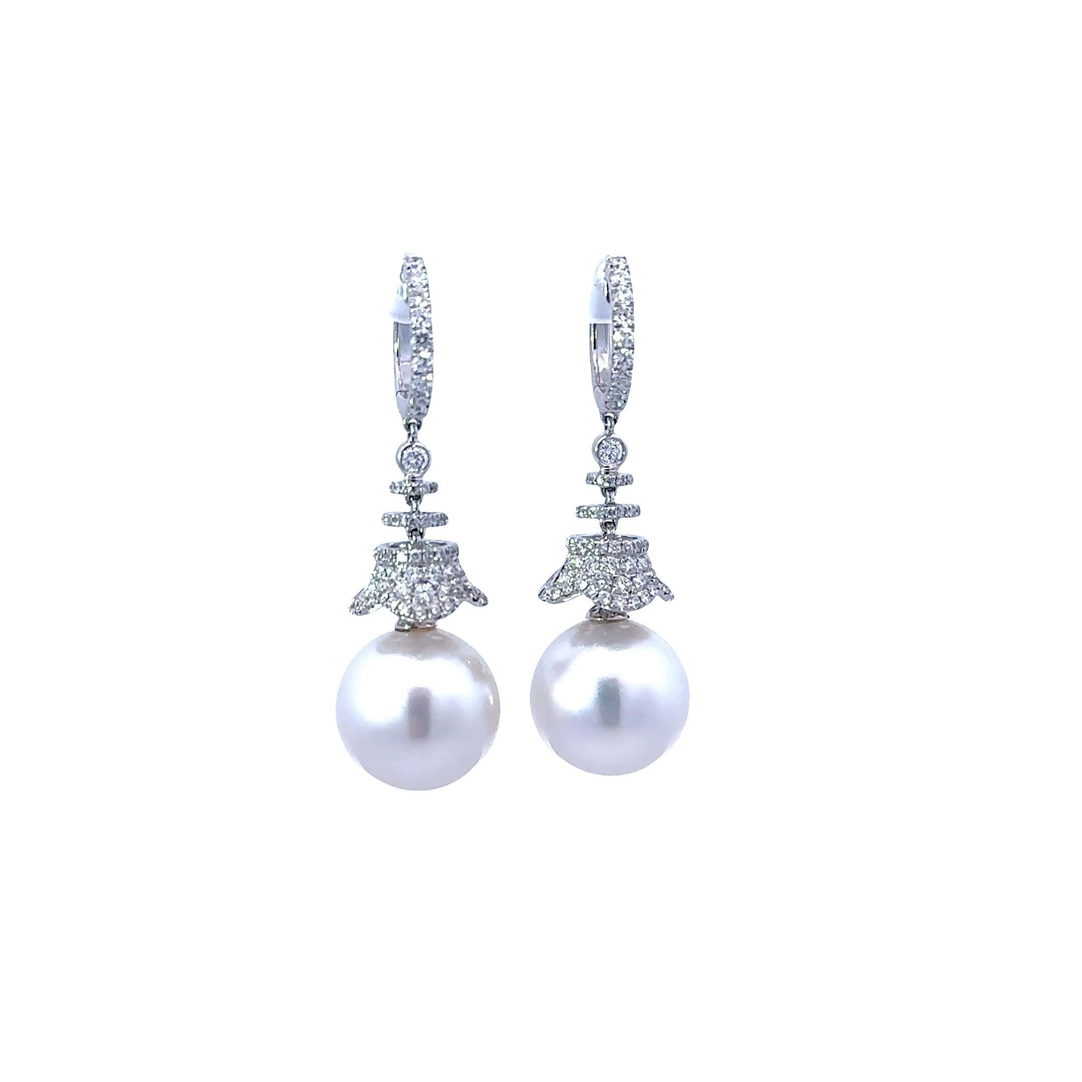 Collectionnées en or blanc 18 carats, ces boucles d'oreilles pendantes sont un ajout raffiné à toute collection. Cette paire de perles des mers du Sud de qualité AAA mesure 14 mm chacune et présente un lustre et une nacre d'une grande qualité, sans