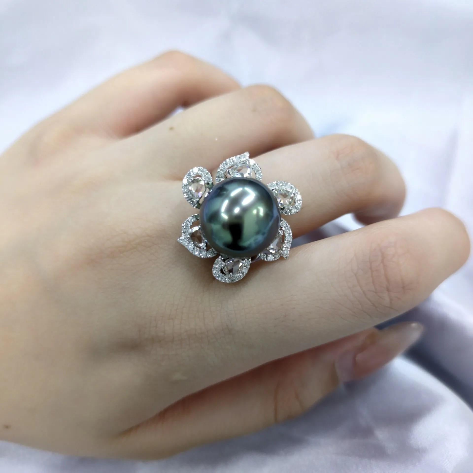 This exquisite ring features a magnificent Tahitian pearl as its centerpiece. The pearl, measuring an impressive 14mm in diameter, showcases a deep, alluring black or peacock green color, characteristic of these rare gems. It is set in a delicate