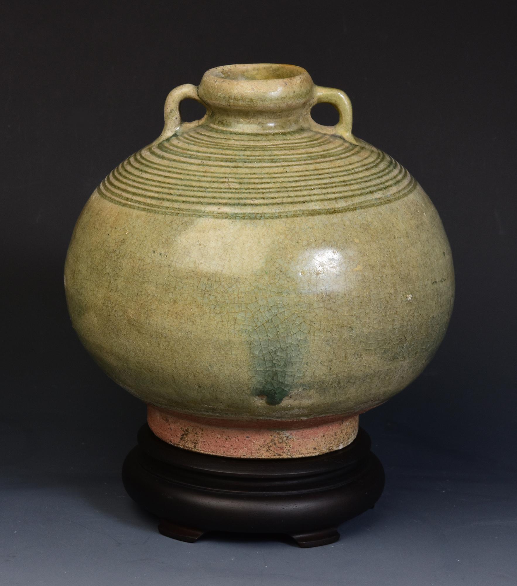 Antique Thai Sukhothai celadon glazed pottery bottle.

Age: Thailand, Sukhothai Period, 14th - 16th Century
Size: Height 17 C.M. / Width 17.4 C.M. (size excluding stand)
Condition: Nice glaze and condition overall (some expected degradation due to