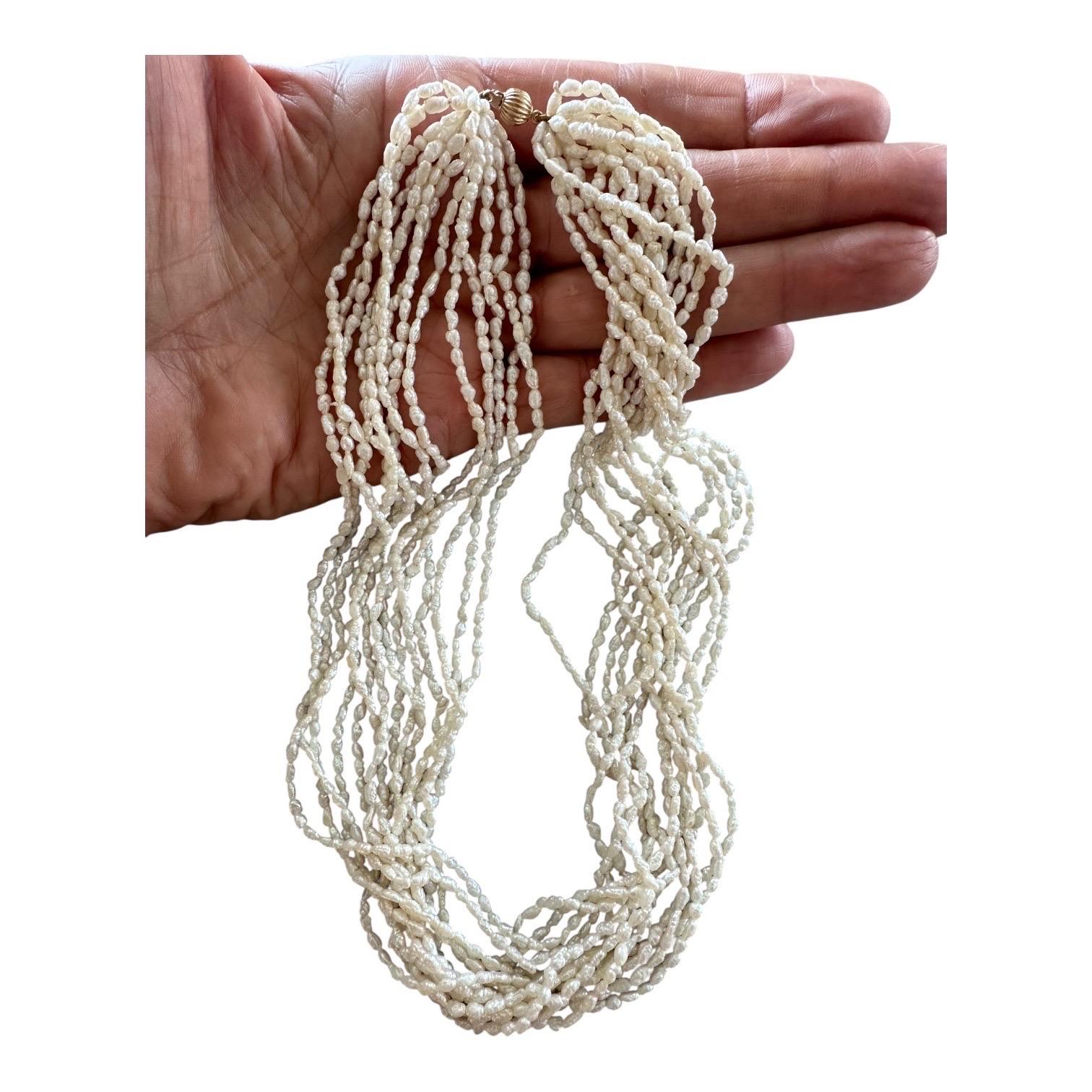 Queste deliziose perle di semi hanno una lunghezza di 18 pollici. I 14 fili possono essere indossati come una collana intrecciata o come un look a strati per un'edizione straordinaria del guardaroba. Una parete gialla da 14 carati è ondulata come un