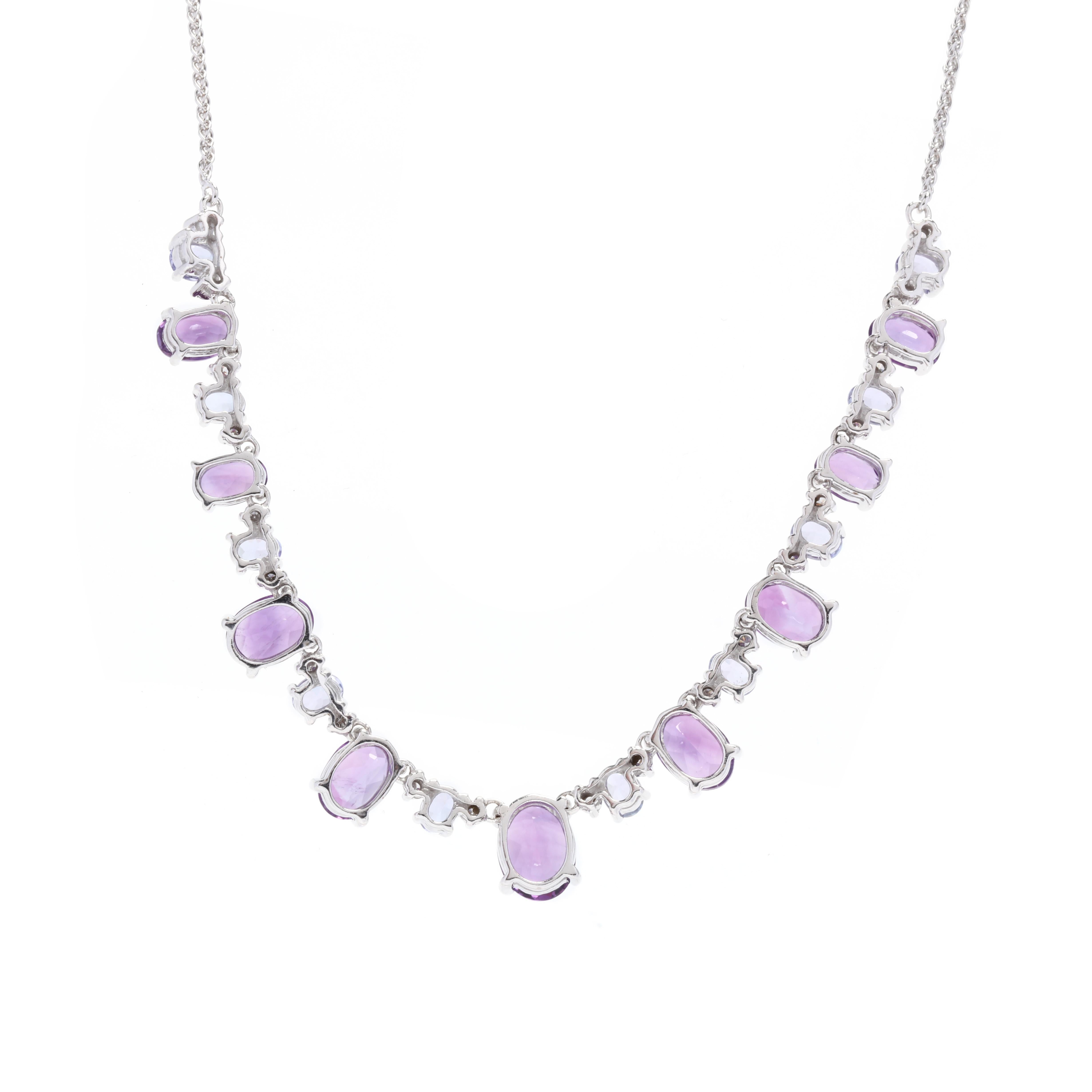 A 14 karat white gold amethyst, tanzanite and diamond collar necklace. This necklace features alternating oval cut amethysts weighing approximately 5.84 carats, oval cut tanzanites weighing approximately 2 total carats, and full cut round diamonds
