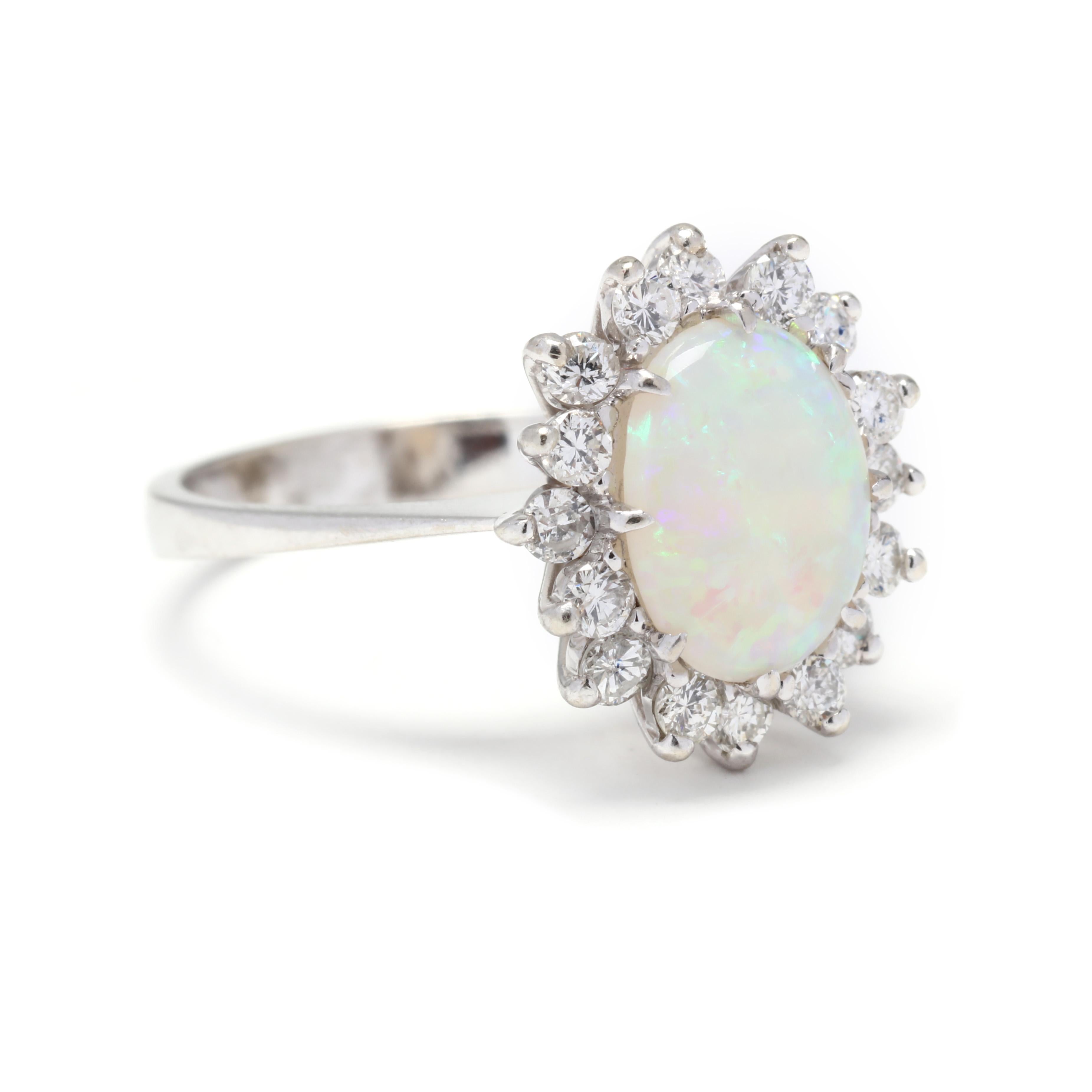 A 14 karat white gold opald diamond ring. This ring features a prong set, oval cabochon opal weighing approximately 1.50 carats surrounded by a halo of full cut round diamonds weighing approximately .56 total carats and with a thing slightly tapered