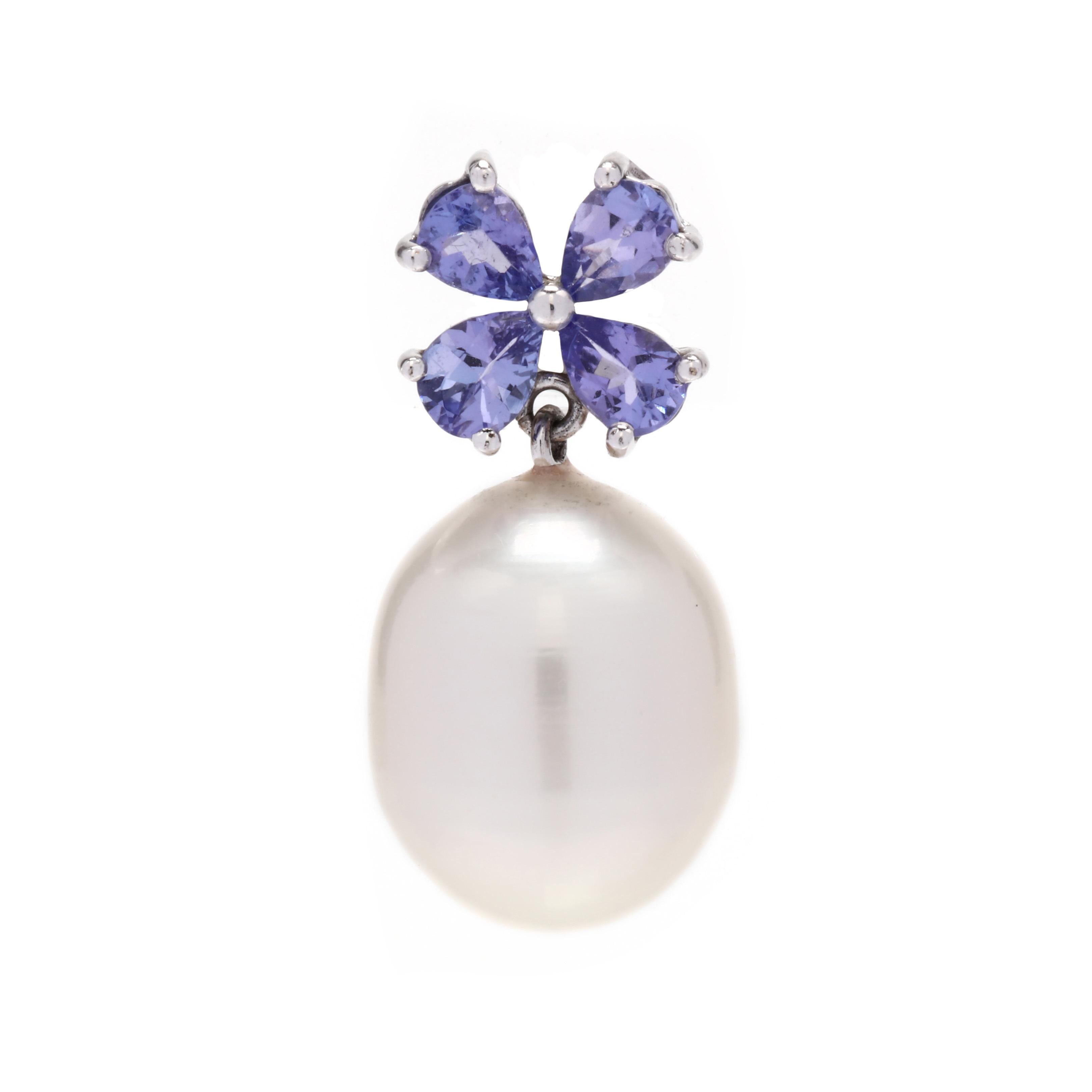 A pair of 14 karat white gold tanzanite and pearl drop earrings. These earrings feature a cluster of pear shape tanzanites weighing approximately 1.28 total carats in a floral motif with an oblong pearl drop and pierced butterfly push