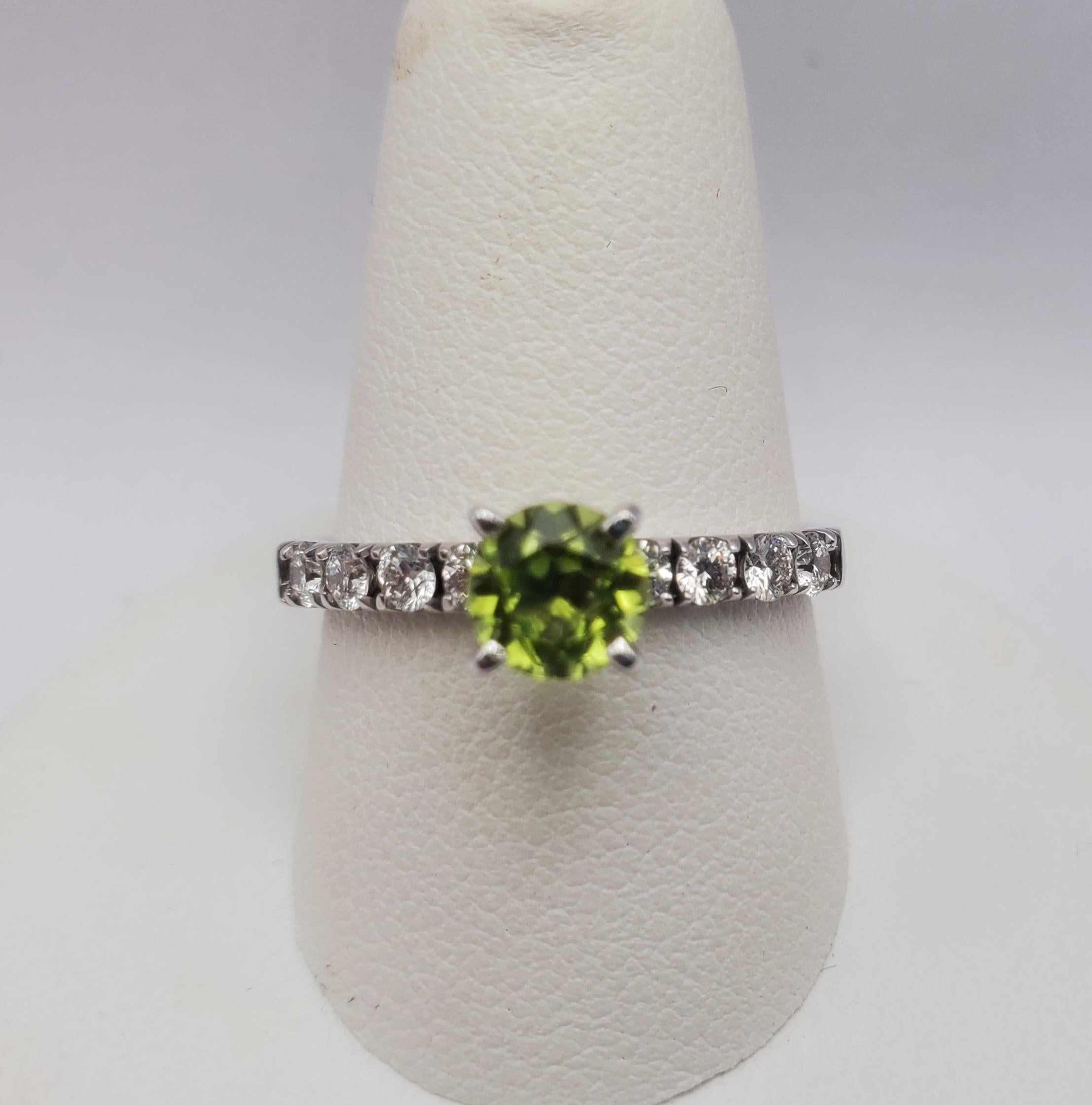 Precioso anillo de oro blanco de 14k, peridoto y diamantes. Este anillo presenta una piedra central de peridoto natural de talla brillante redonda de 0,73 ct y ocho diamantes naturales de talla brillante redonda con un peso total de 0,40 ct. El