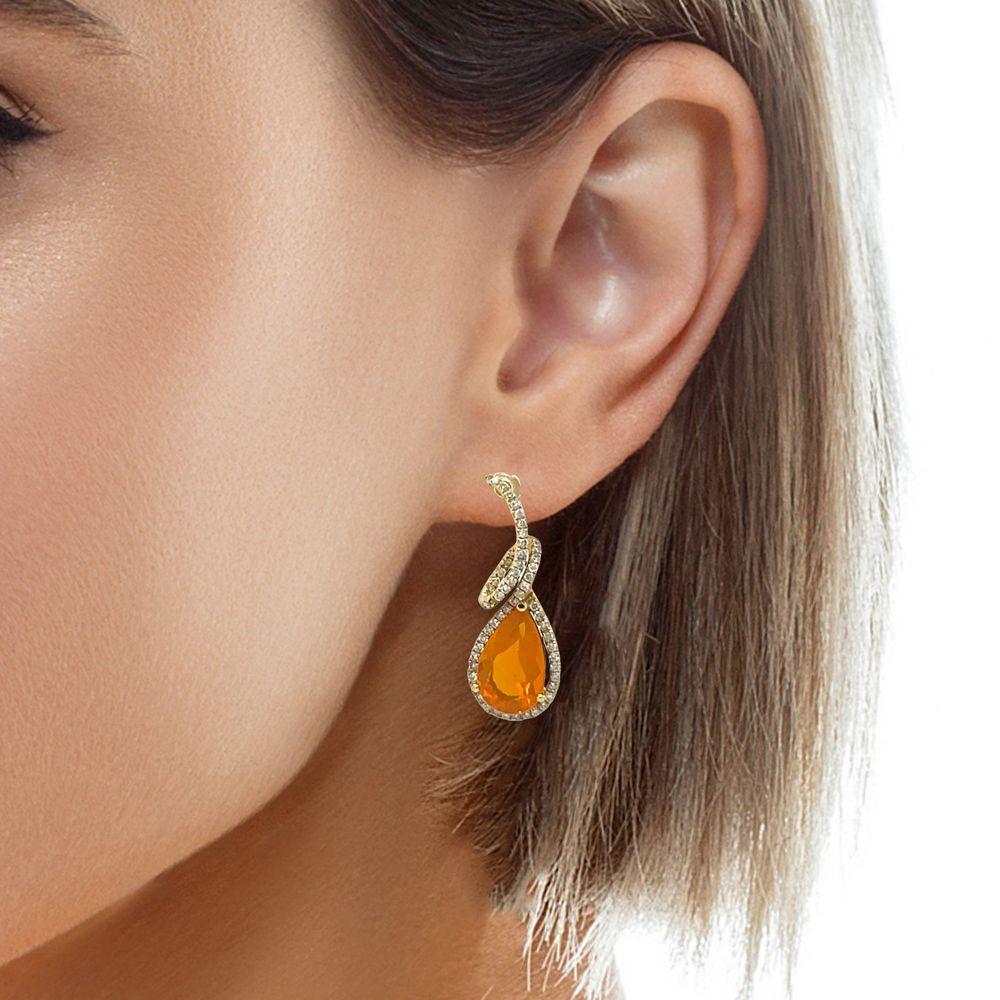 These vibrant 14x8 mm Teardrop Fire Opal and diamond dangling earrings are set in 14 karat yellow gold. They are stunning to wear at that special event. They have a halo of sparkling diamonds and a swirl design for a beautiful accent. These earrings