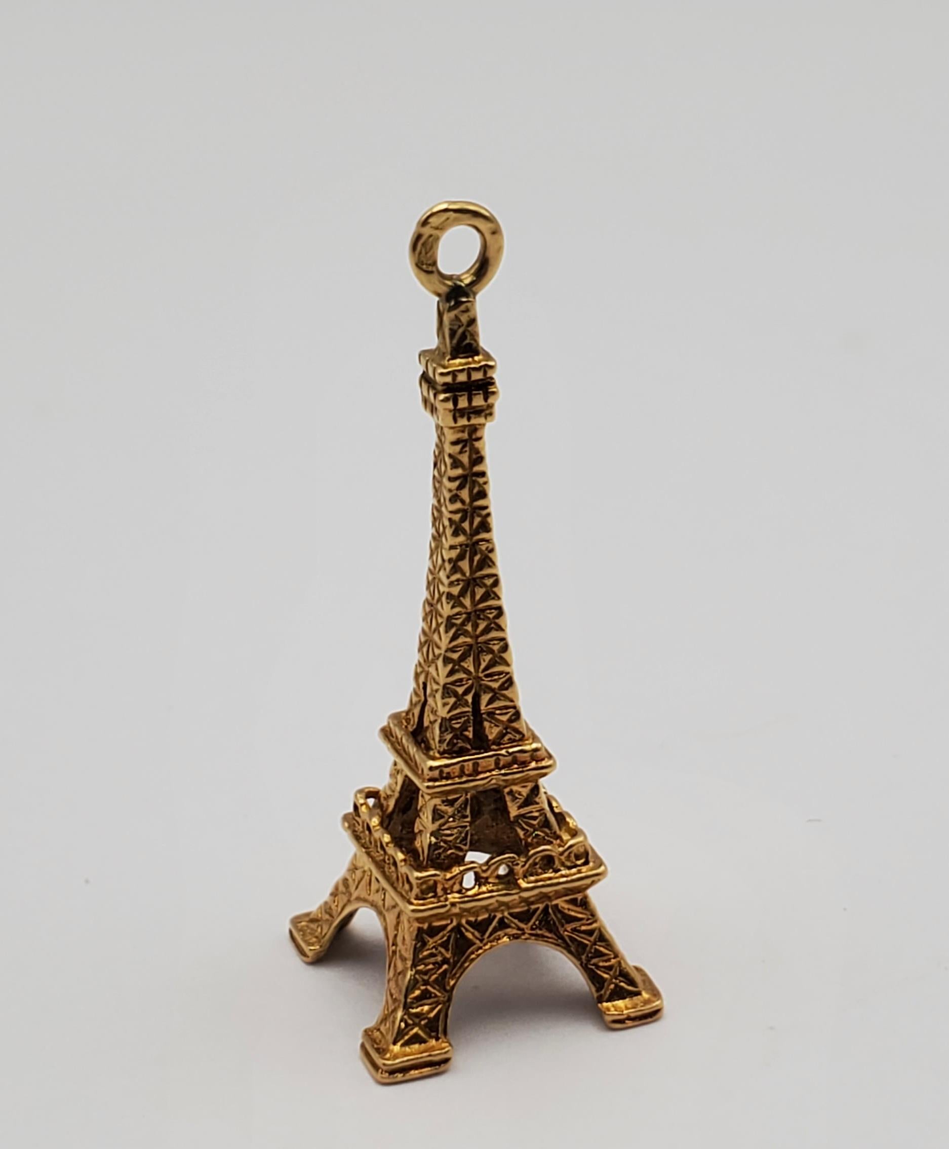 14K Solid yellow gold beautifully carved Eiffel Tower charm. The charm features intricate detailing reflective of the iconic landmark. It could be added to a charm bracelet as a timeless souvenir or worn on a chain as a unique pendant. 

The piece