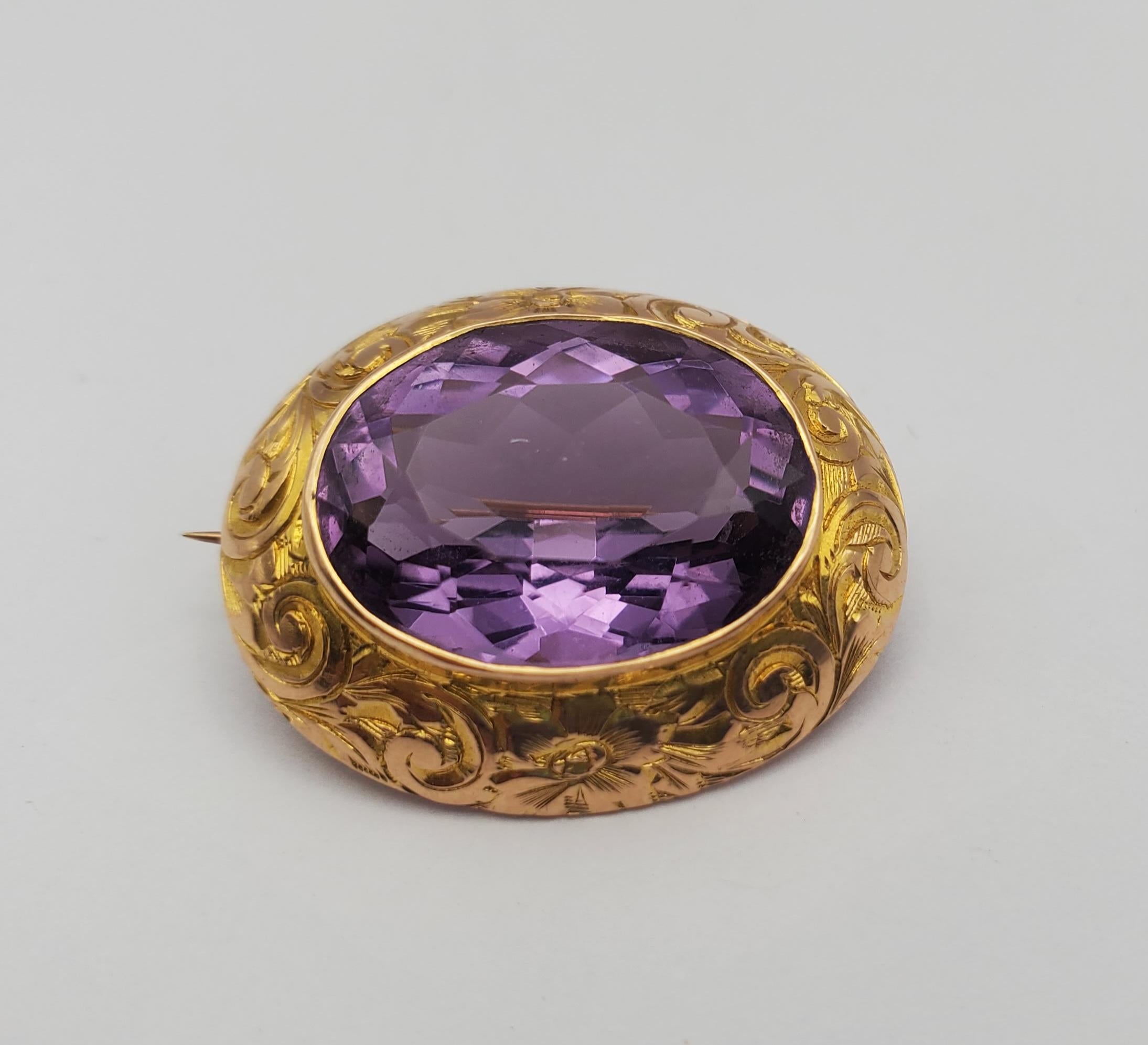 This striking amethyst brooch is an estate piece originating from the late nineteenth to early twentieth century. The setting is 14k yellow gold featuring a beautifully cut oval center stone. The stone is bezel set and the setting features a