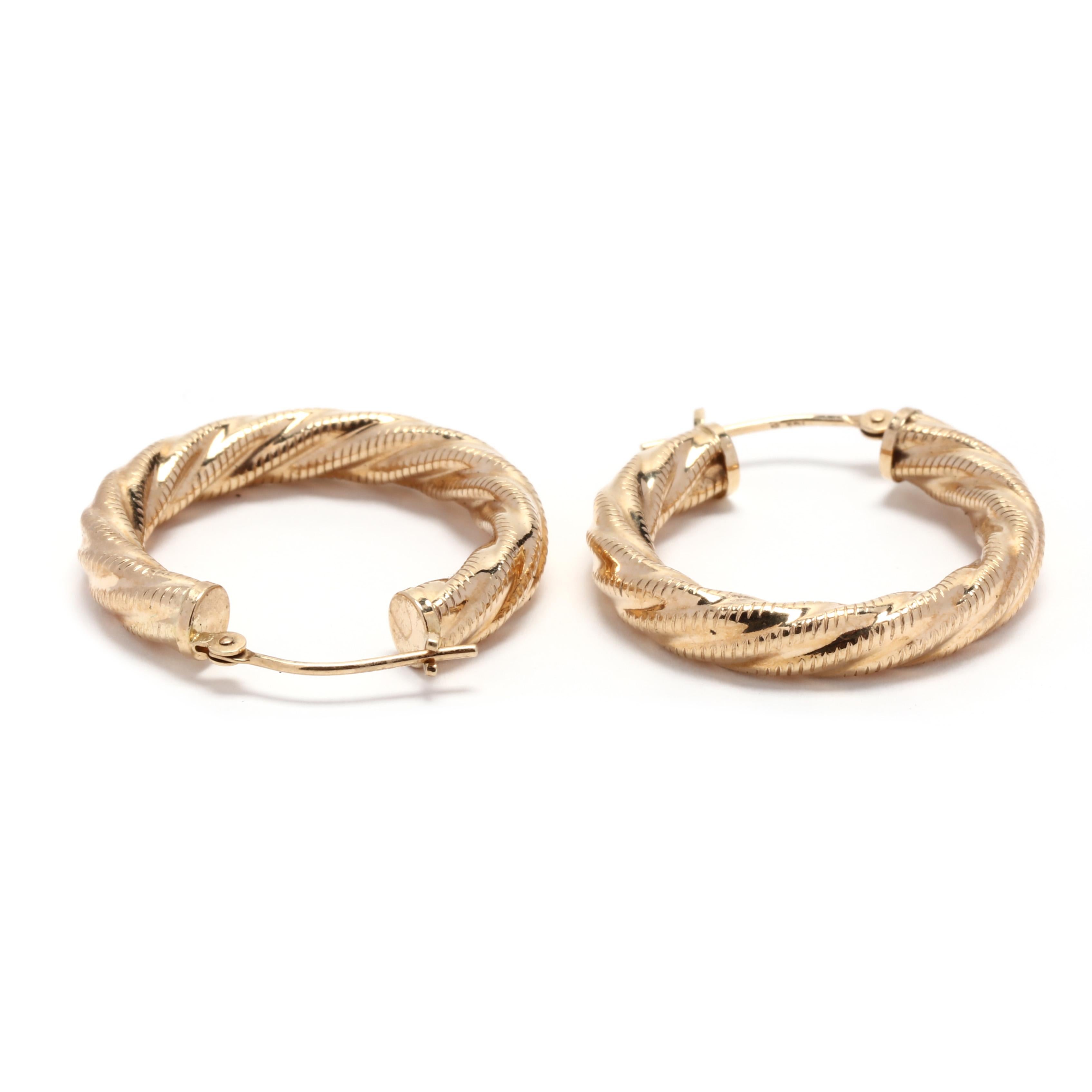 A pair of 14 karat yellow gold twist croissant hoops. These earrings features a textured design in a cable motif with a pierced snap closure.



Length: 1 in.



Width: 4.1 mm



Weight: 1.4 dwts.