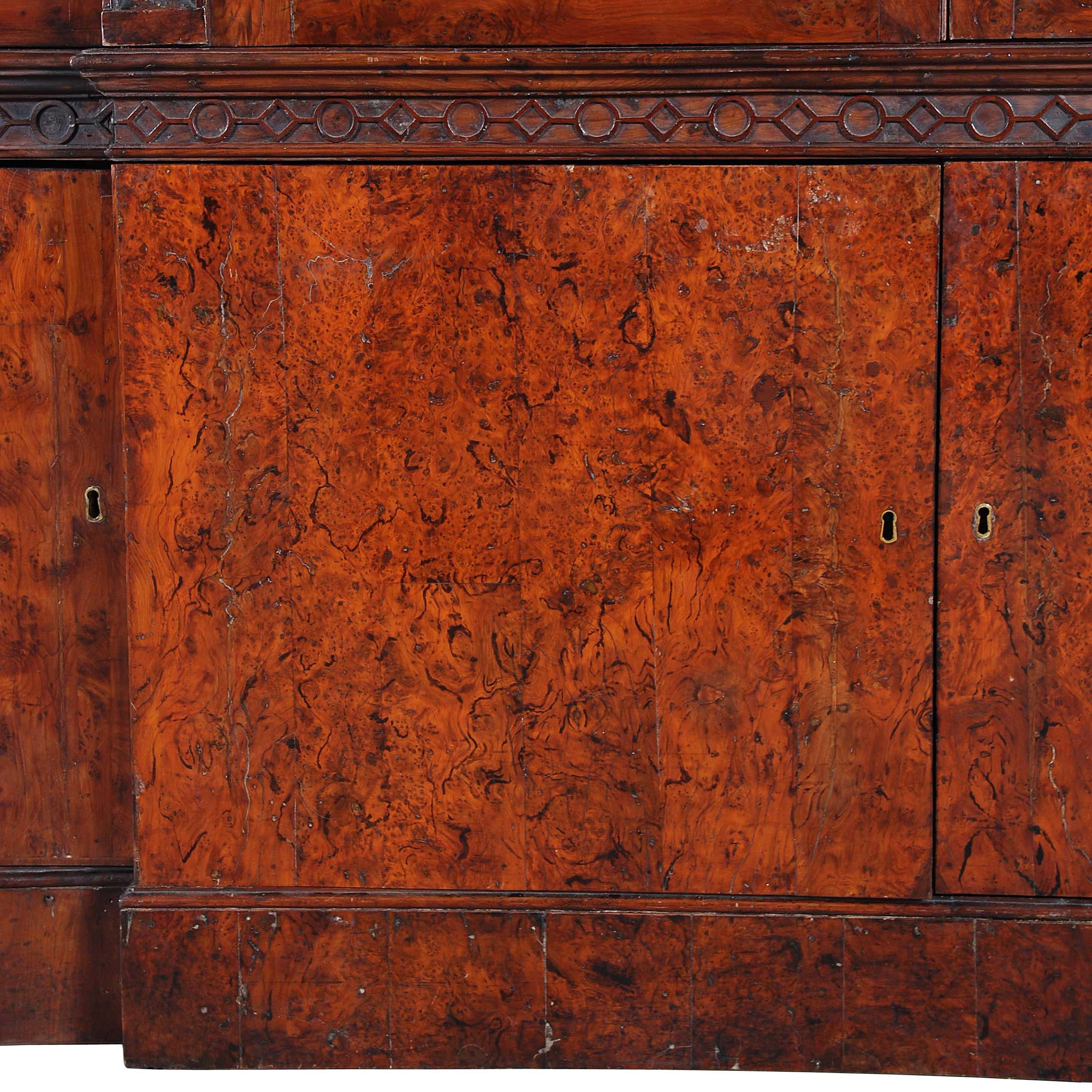 Una libreria estremamente lunga di forma bifronte. Raro per l'uso di impiallacciature in legno di tasso estremamente figurate in tutta la struttura. Gli astragali delle porte vetrate a 12 pannelli sono realizzati in legno massiccio di tasso. Con un