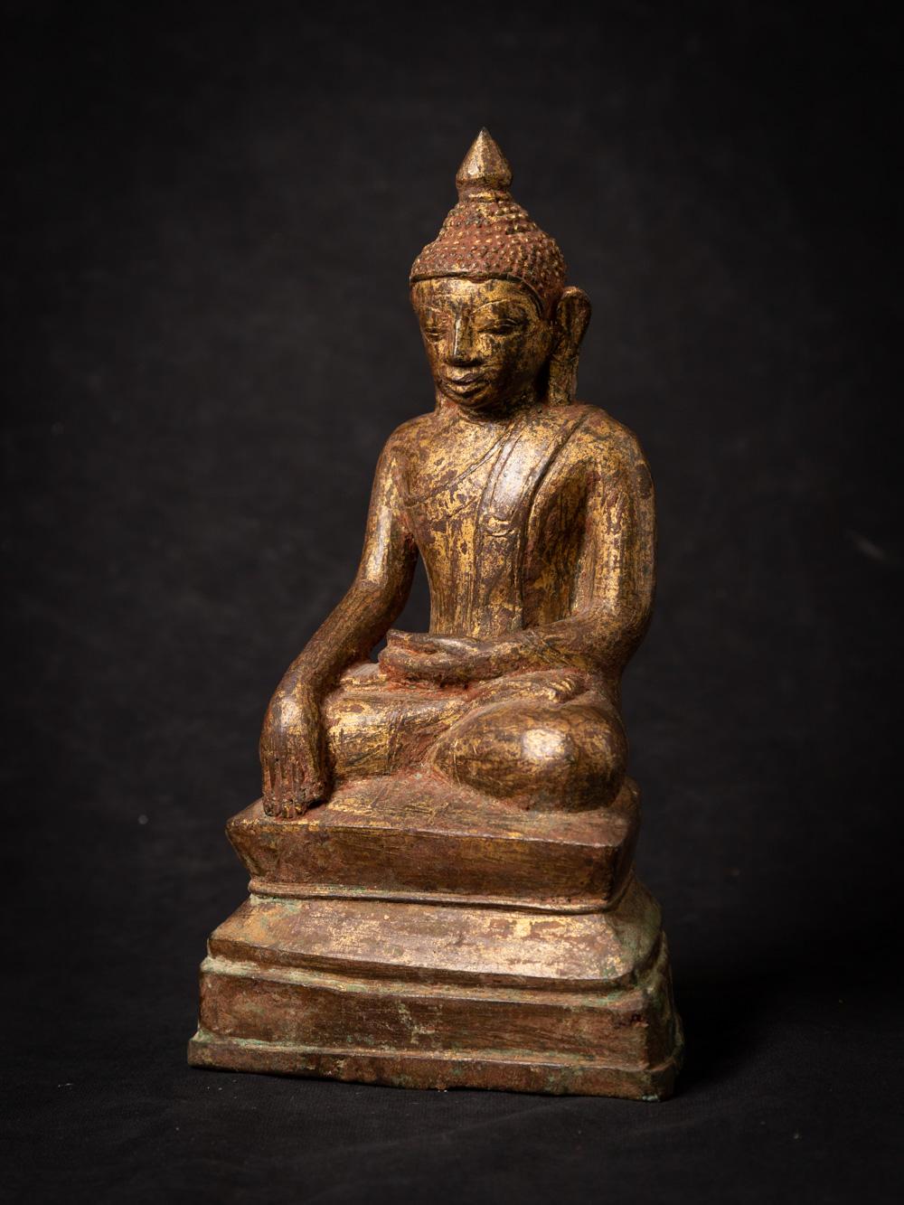 The antique bronze Burmese Buddha statue is a captivating and sacred artifact originating from Burma. Crafted from bronze and gilded with 24-karat gold, this statue stands at 22.1 cm in height and measures 12.9 cm in width and 7.7 cm in depth. The