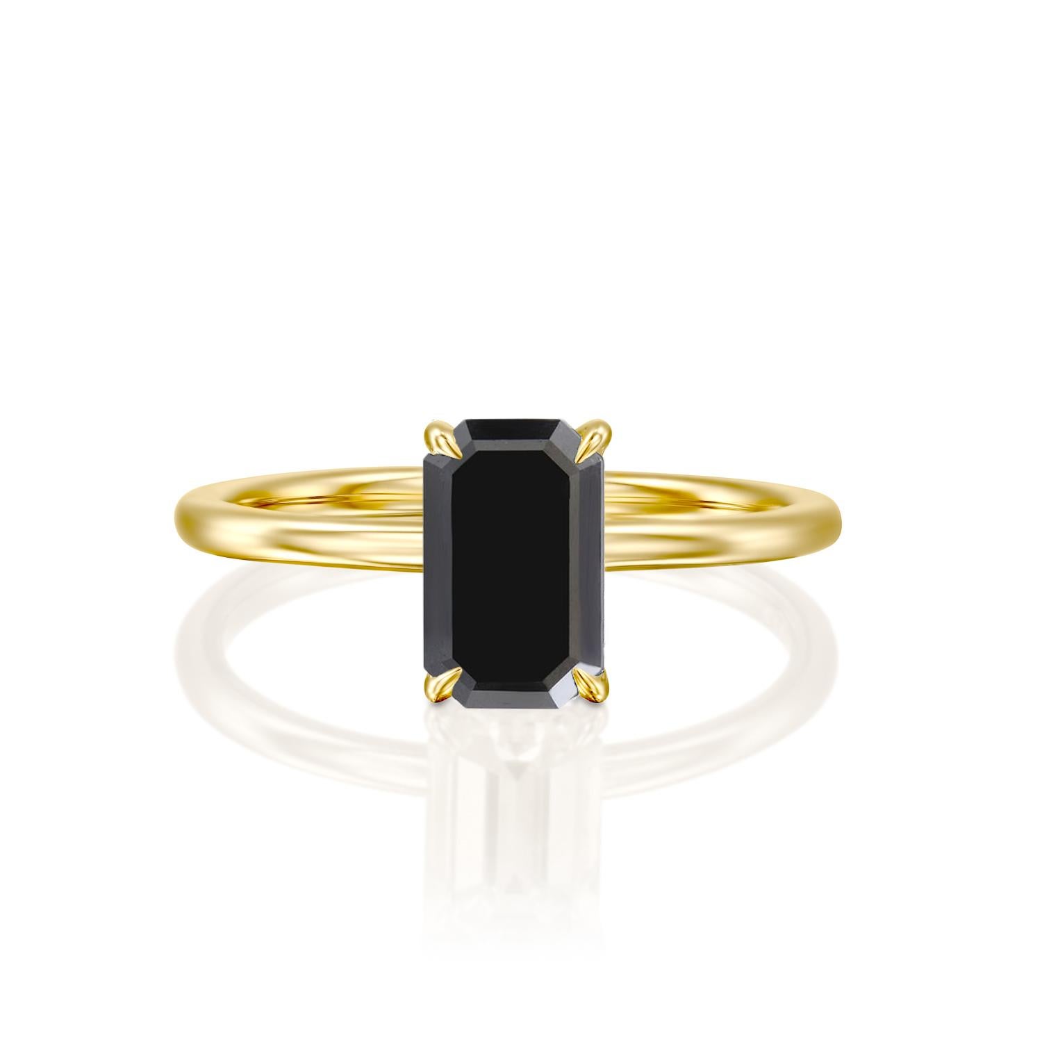Beautiful minimalistic black diamond engagement ring ring. Center stone is of 1.5 carat, natural, emerald shaped, AAA quality Black diamond. Set in a sleek, 14K yellow gold, solitaire ring with a 4-prong setting. The setting looks delicate but is