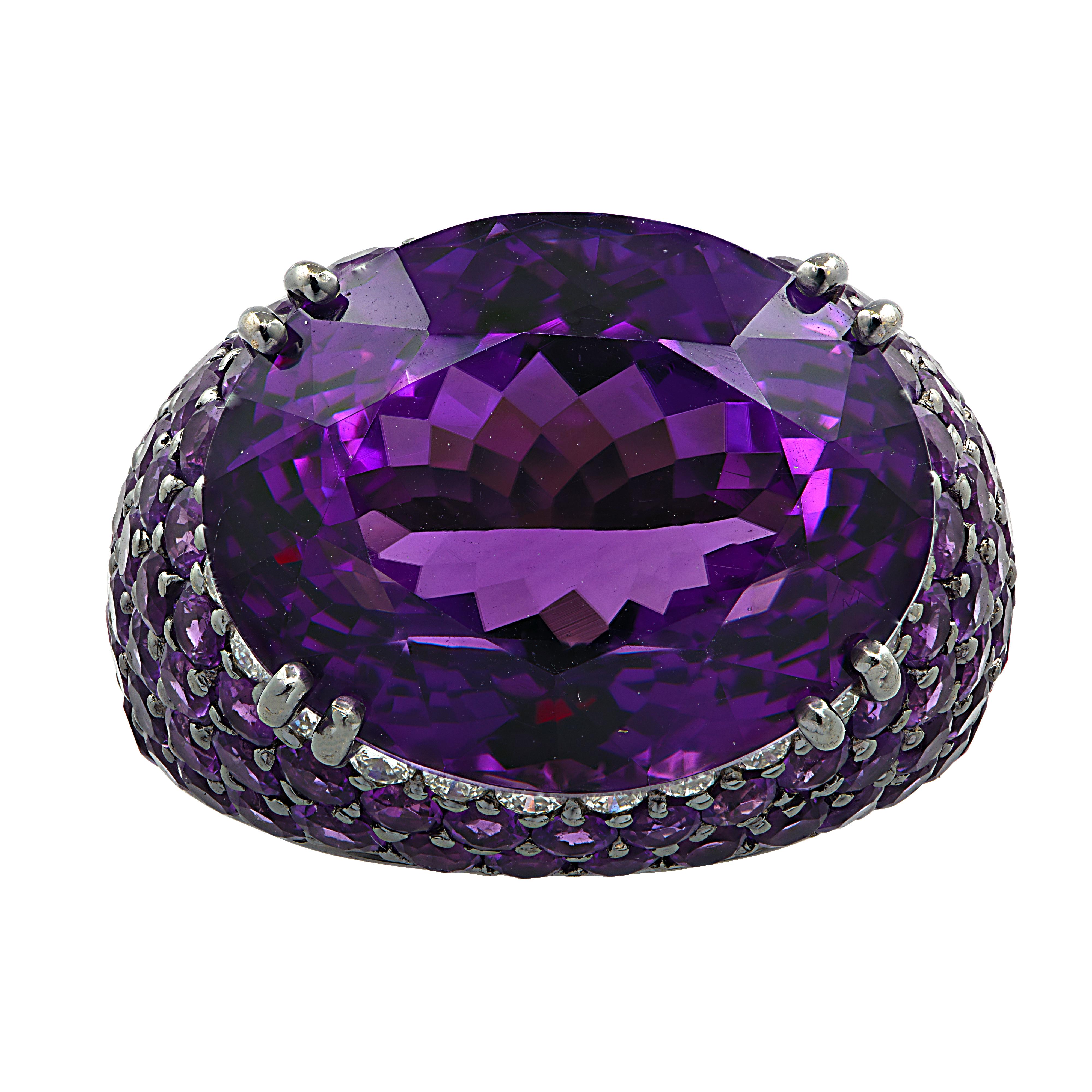 Magnificent cocktail ring crafted in 18 karat white gold and black rhodium, showcasing a sensational oval amethyst weighing approximately 15 carats adorned with 24 round brilliant cut diamonds weighing approximately 0.5 carats total, G color, VS