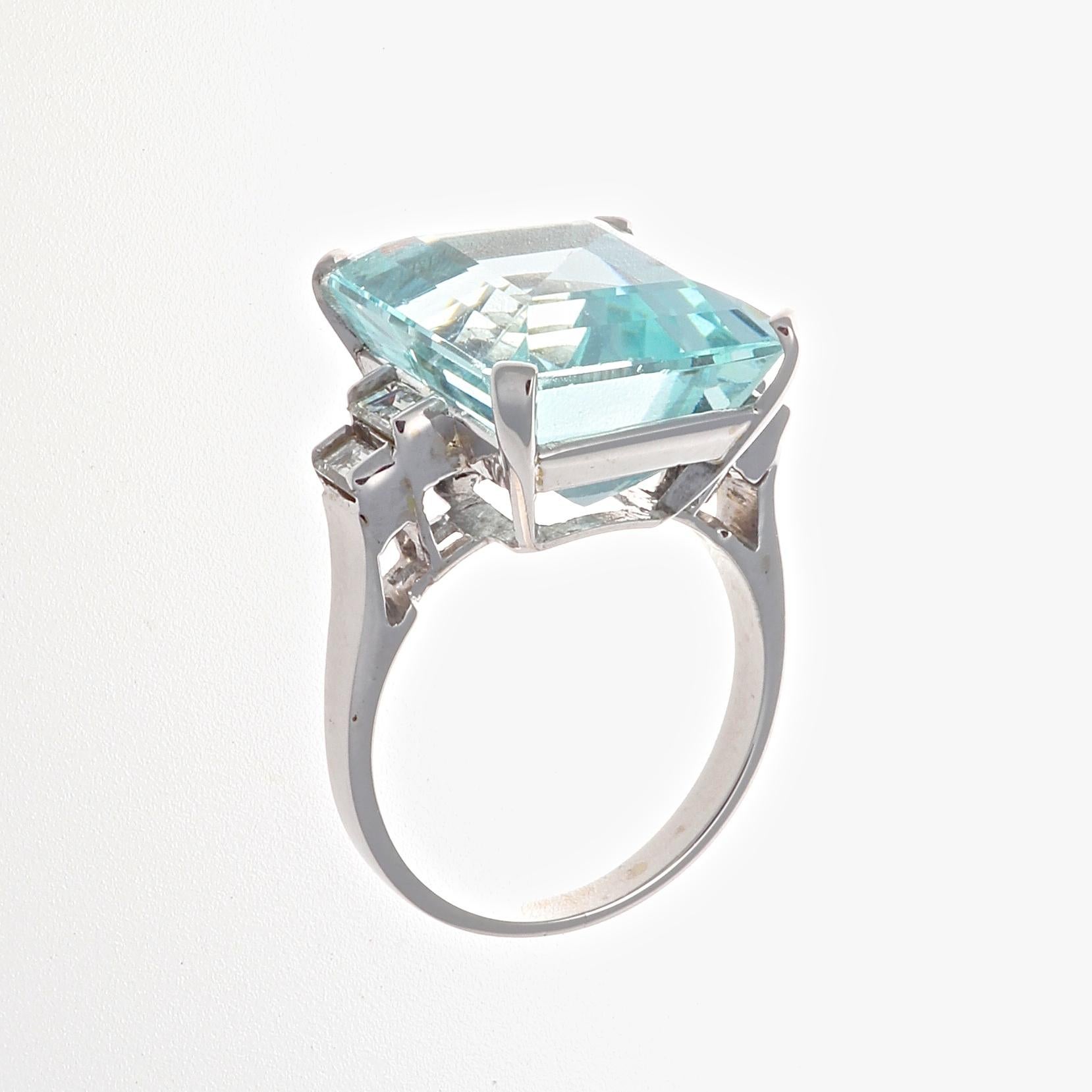 Serene, fresh and sparkling like the ocean. Believed to be the treasure of mermaids and the stone of eternal youth. Featuring an approximately 15 carat aquamarine accented by  emerald cut diamonds on either side. Crafted in 18k white gold. Ring size