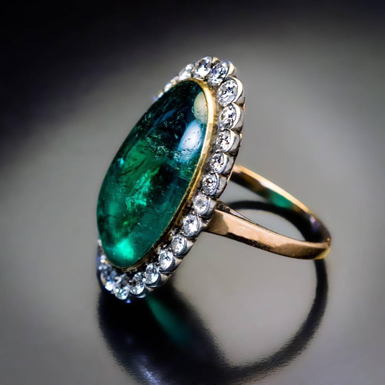 Circa 1930s – 1940s

A handcrafted silver-topped 14K gold ring is bezel-set with a large Colombian cabochon cut emerald measuring 20.7 x 13.5 x 7.32 mm (approximately 15.30 ct) framed by old and modern cut brilliant diamonds. Estimated total diamond