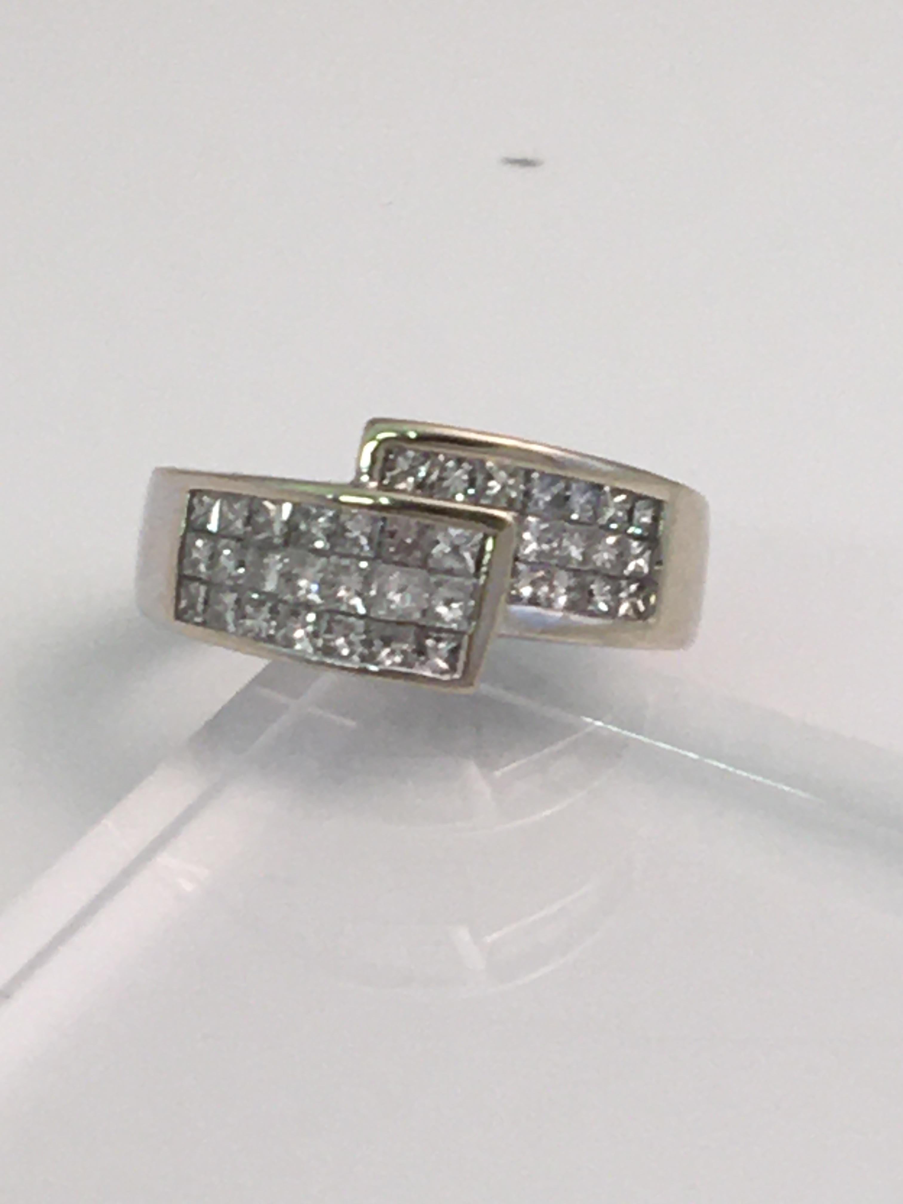 This beautiful bypass ring is easy to wear and looks good on any finger.
36 square cut diamonds approximately 1.50 total diamond weight
G-H VS-SI quality diamonds, invisibly set
14 karat white gold 
Stamped 