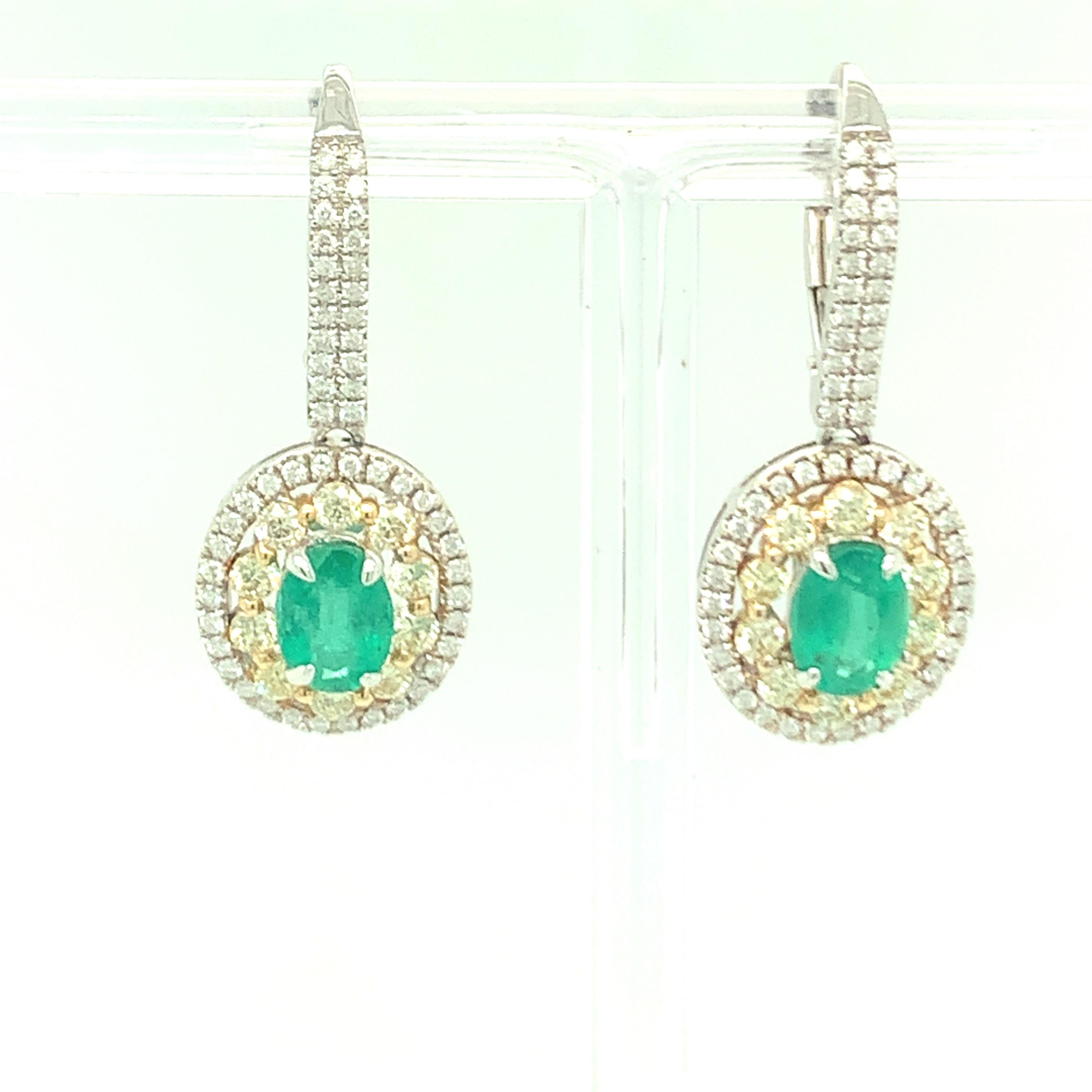 This oval shaped emerald earrings has two rows of diamond halo. Inner row is of yellow diamond and outer row of white diamond with pave setting on front lever. Green emerald marries the combination of yellow and white diamond very well. Finished