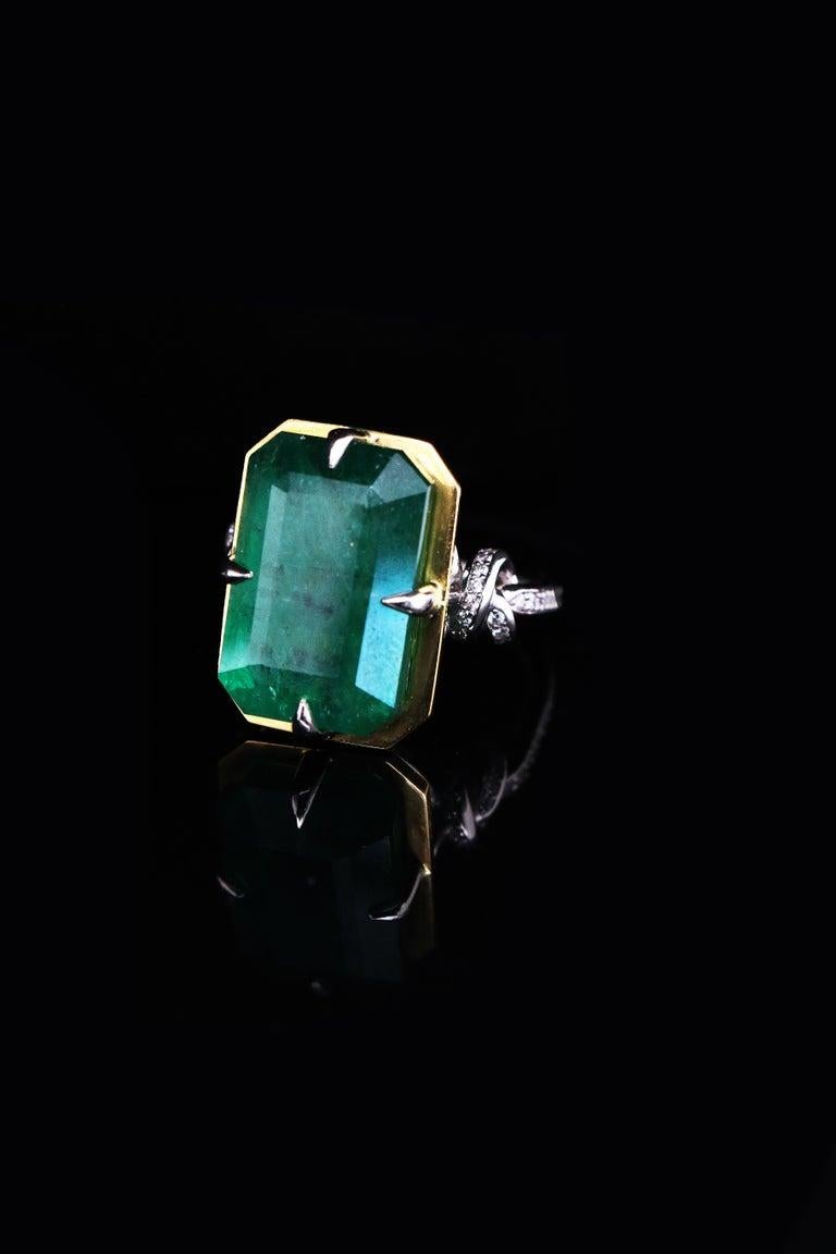Glamorously bold and unabashedly seductive. This showstopper one of a kind ring features an intense 15ct natural Emerald poised between sharp eagle style talons and embraced by powerful-platinum, diamond encrusted ropes, converging to two knots on