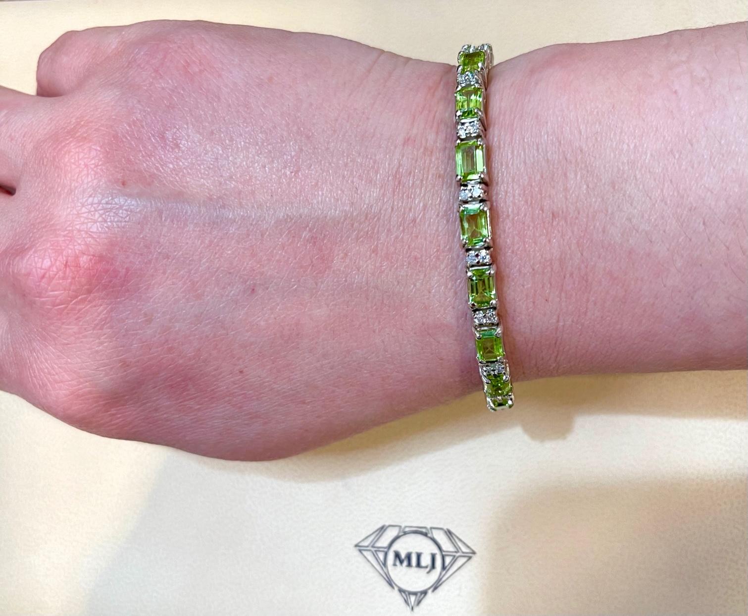  This exceptionally affordable Tennis  bracelet has  19 stones of Emerald cut Peridot
Beautiful colors , very Vibrant
Size of the stone is approximately 7X5 mm
Each Peridot  is spaced by two brilliant round Diamonds.
Total weight of the Diamond is