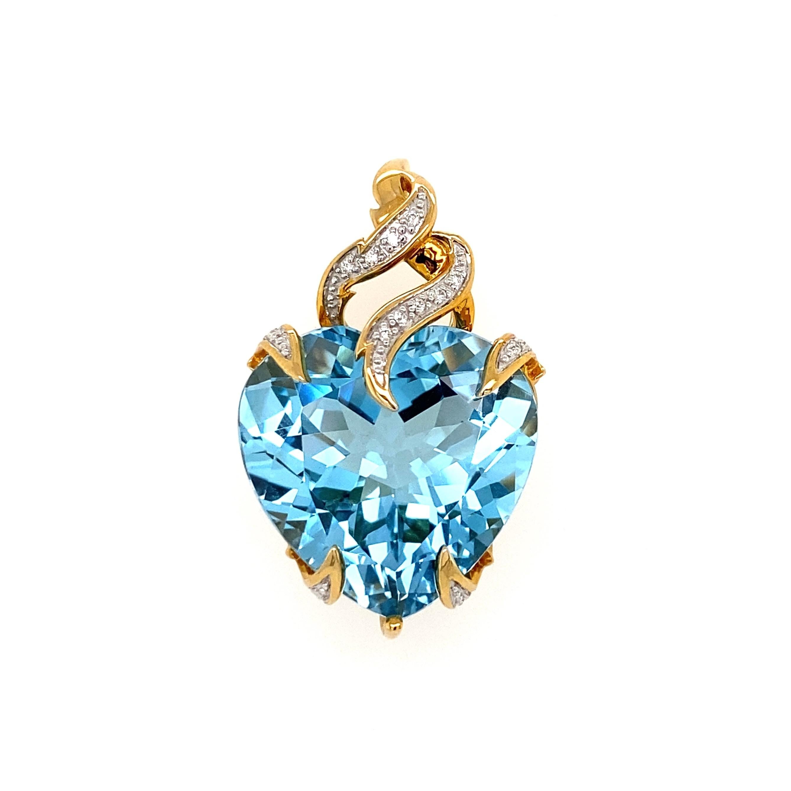 Simply Beautiful! Finely Detailed Gemstone Blue Topaz Heart and Diamond Gold Pendant. Centering a Hand set 15 Carat Heart shaped Topaz, approx. 1.25” long, accented by Diamonds, approx. 0.21tcw. Hand crafted in 14K Yellow Gold. More Beautiful in