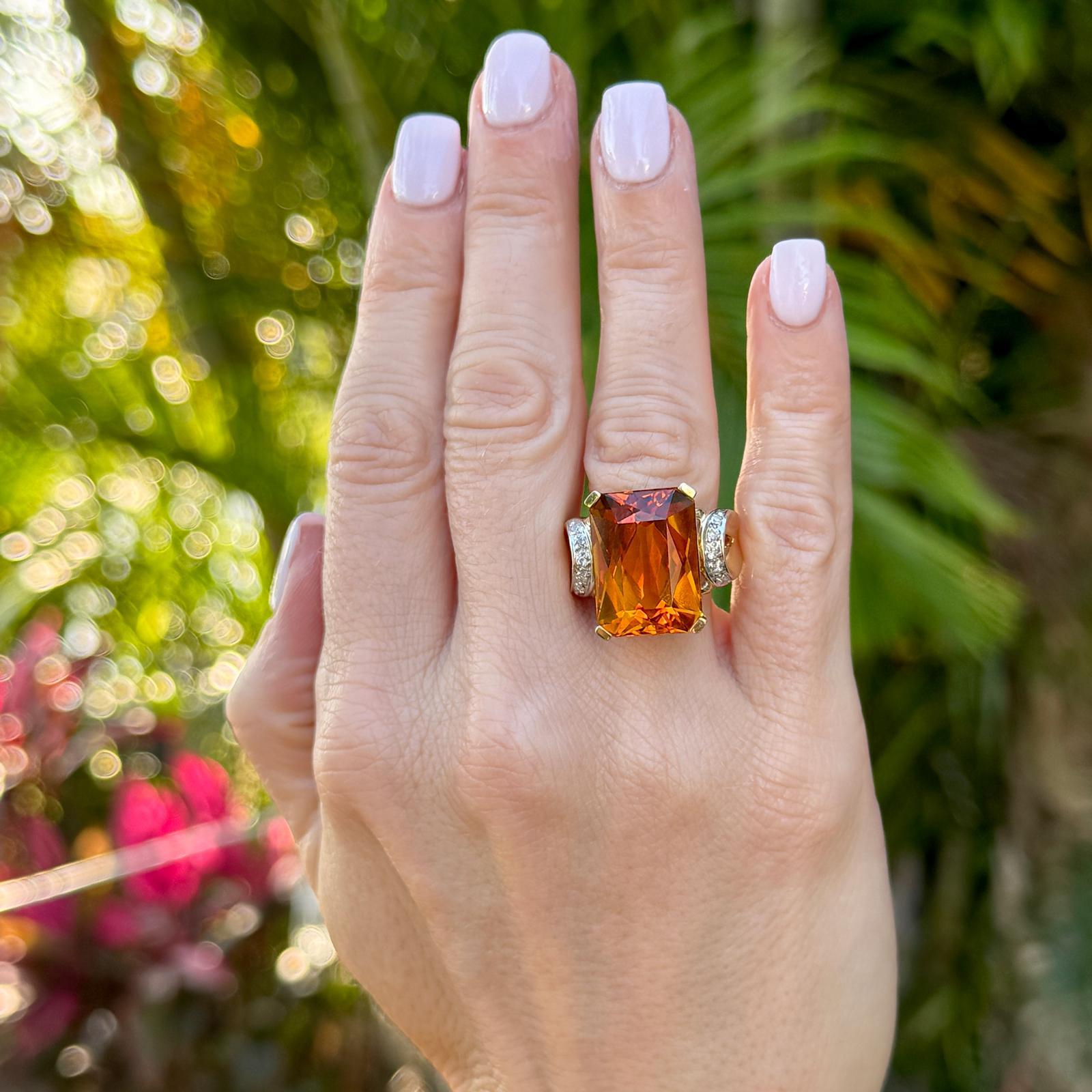 The centerpiece of ths ring is a stunning 15 carat honey citrine gemstone. Honey citrine, with its warm, golden-yellow hue reminiscent of honey, is both striking and elegant. The 10 single cut diamonds are set as accents on the sides weighing