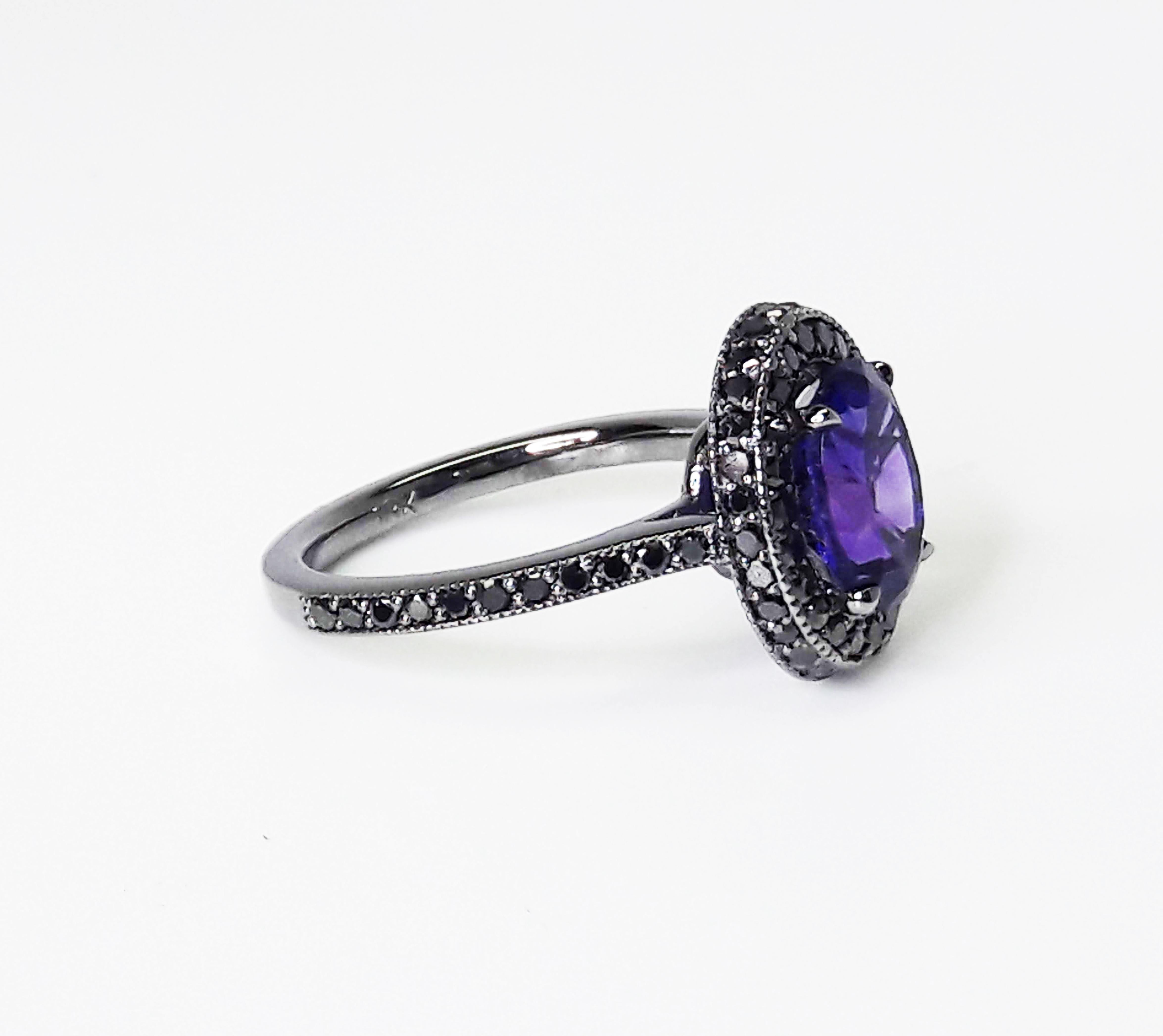 1,5 Karat natürlicher violetter Amethyst, geschmückt mit einem doppelten Halo aus schwarzen Diamanten mit einem Gesamtkaratgewicht von 0,52 Karat, eingefasst in einen handgefertigten Ring aus 18 Karat Weißgold, schwarz rhodiniert.

Handgefertigt in