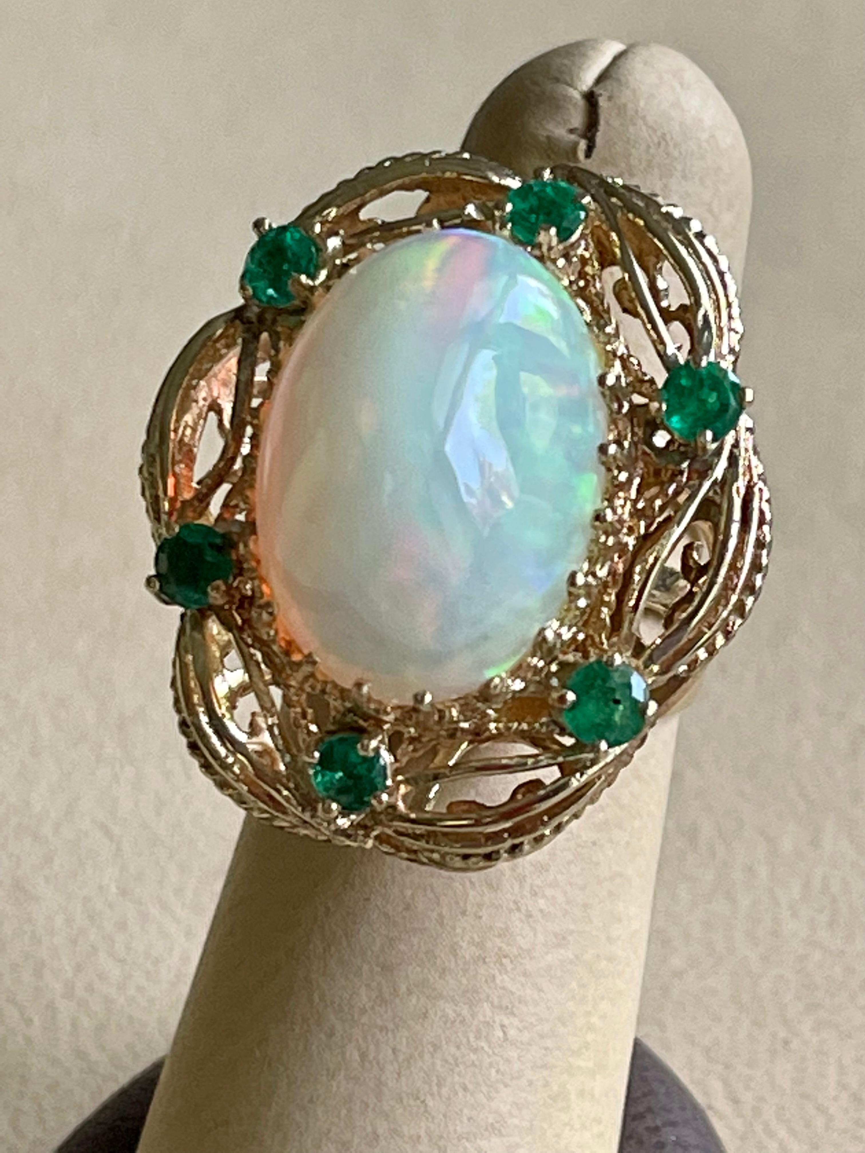 A Huge Cocktail ring 
Approximately 15 Carat Oval Ethiopian Opal  & Emerald Ring 14 Karat Yellow Gold Size 7
This spectacular Ring consisting of a single Oval Shape Ethiopian Opal Approximately 15 Carat. 

very clean Stone no inclusion , full of