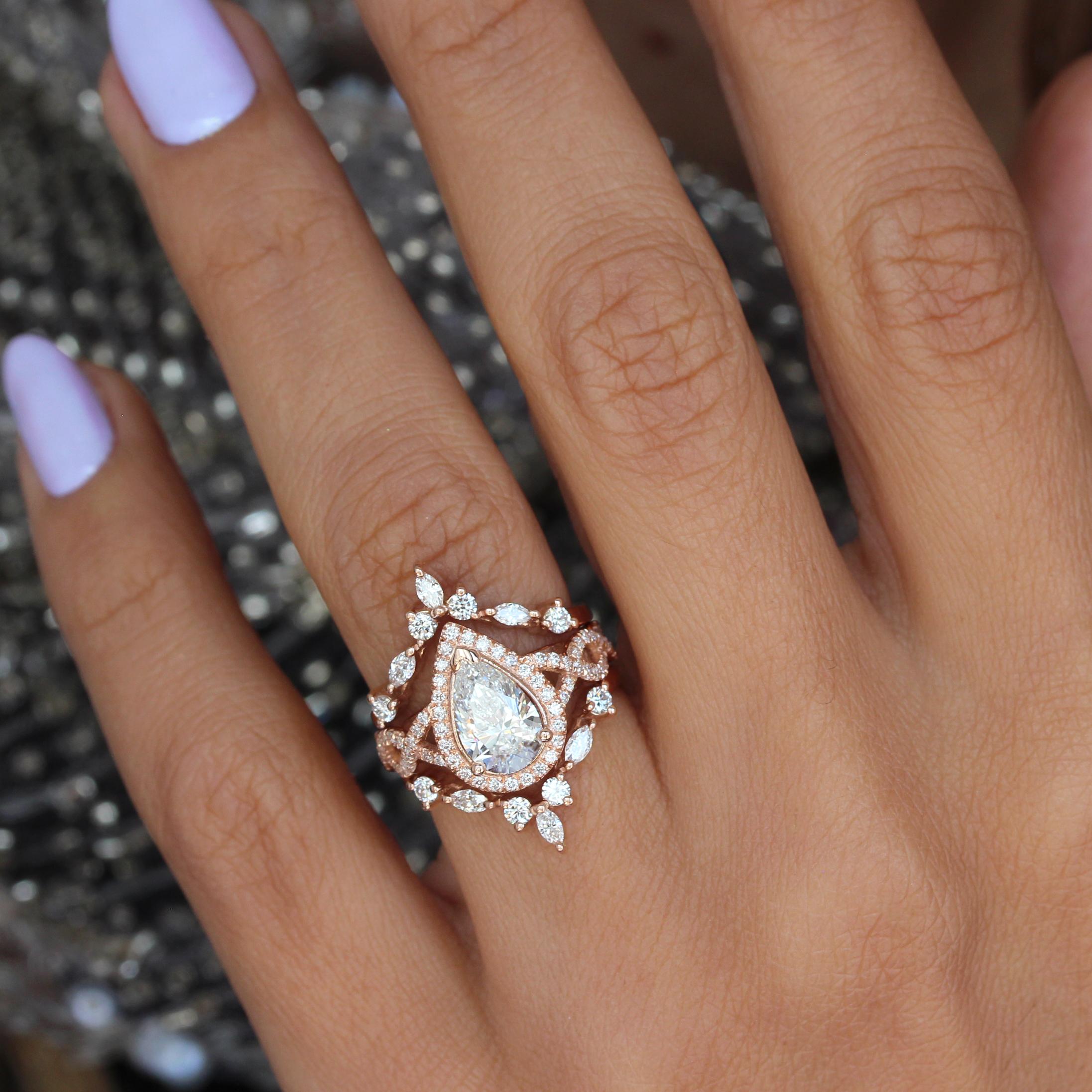 Dieser bezaubernde Verlobungsring hat einen atemberaubenden birnenförmigen 1,5-Karat-Diamant in der Mitte und einen wunderschönen Diamant-Halo. Das mit funkelnden Diamanten und einem Unendlichkeitsmotiv aufwändig gestaltete Twist Shank-Band verleiht
