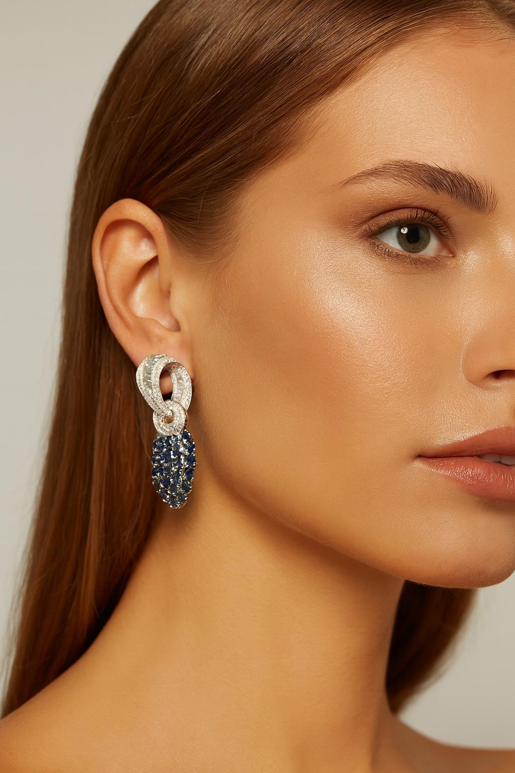 Platin Diamant & Saphir Tag/Nacht Cabrio-Ohrringe
Ein raffiniertes und vielseitiges Paar Ohrringe aus Platin mit einem eleganten Design für jeden Tag und jeden Abend.

Der obere Teil ist mit vollen, rechteckigen und spitz zulaufenden Diamanten im