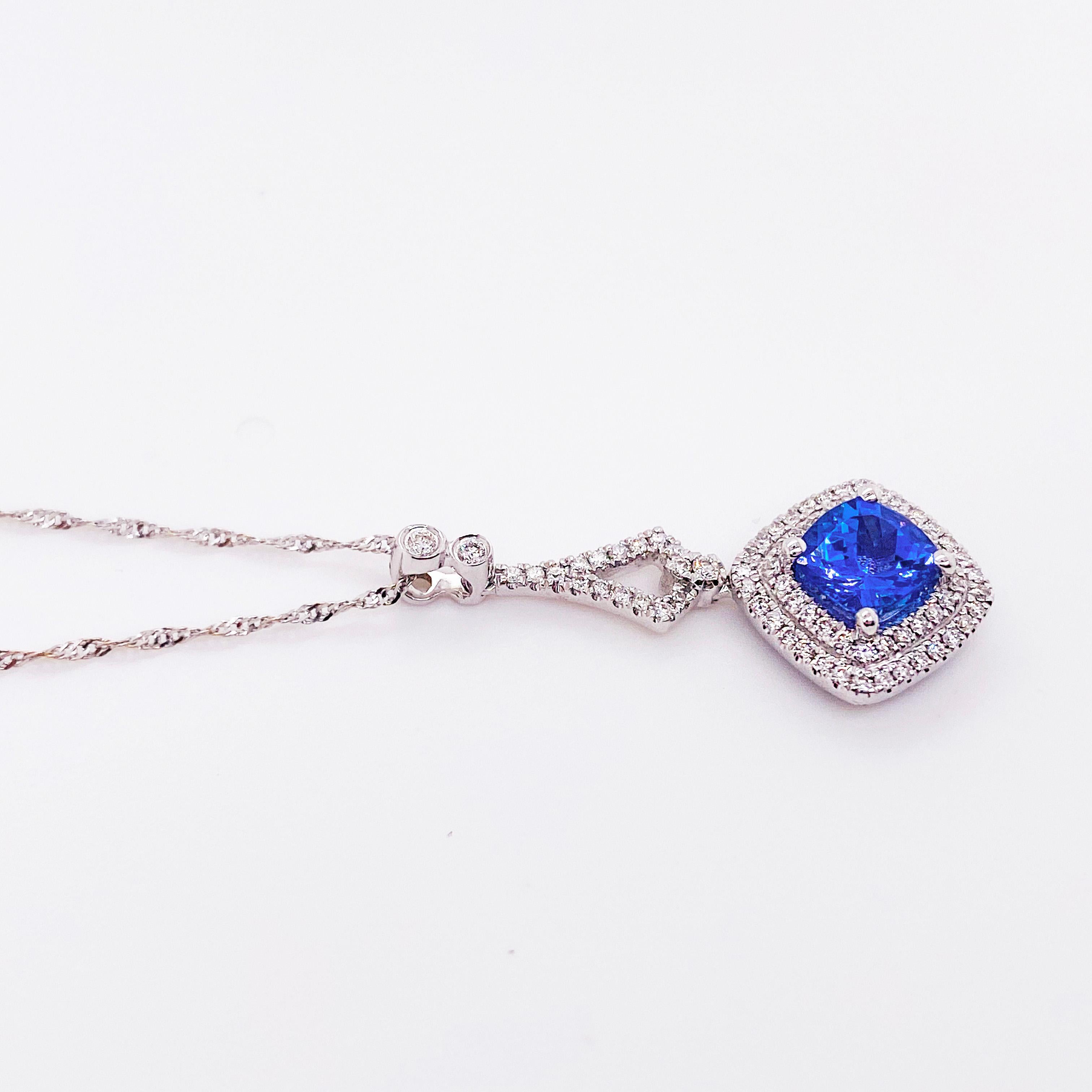 Striking, vibrant tanzanite and double halo diamond pendant! This gorgeous fine jewelry necklace has a cushion shaped tanzanite gemstone set on point with a double diamond halo! The gorgeous color of tanzanite is a purplish-blue color that everyone