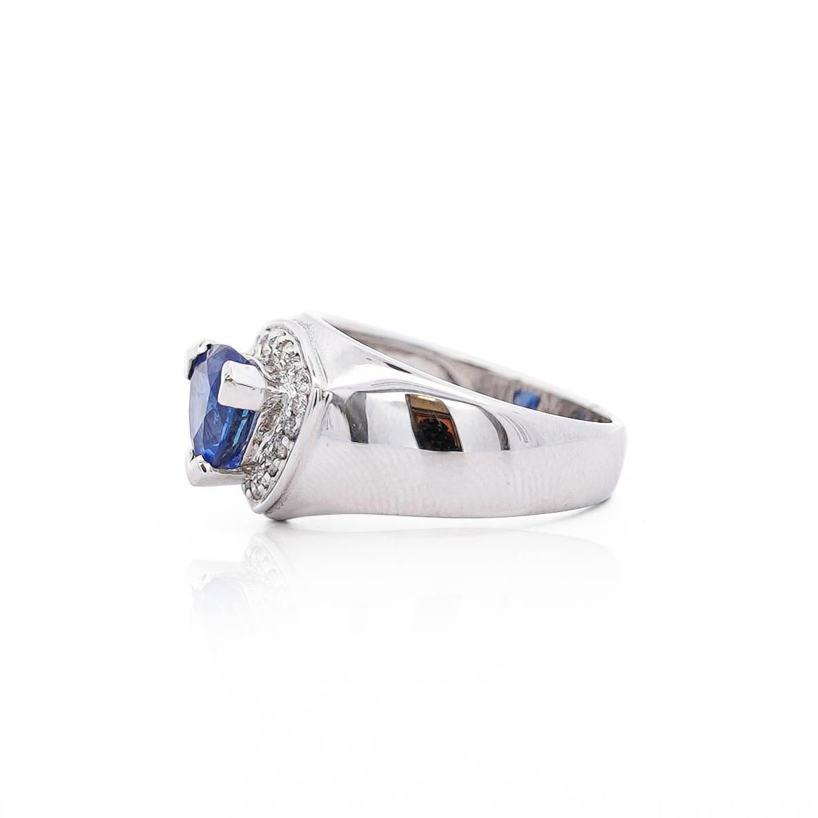 Este anillo midi de oro blanco de 18 quilates tiene un zafiro azul talla trillón de 1,50 quilates engarzado con 3 garras, rodeado de un halo de diamantes de 0,35 quilates. El anillo pesa 8,1 gramos y tiene una atrevida banda de 12 mm de ancho.