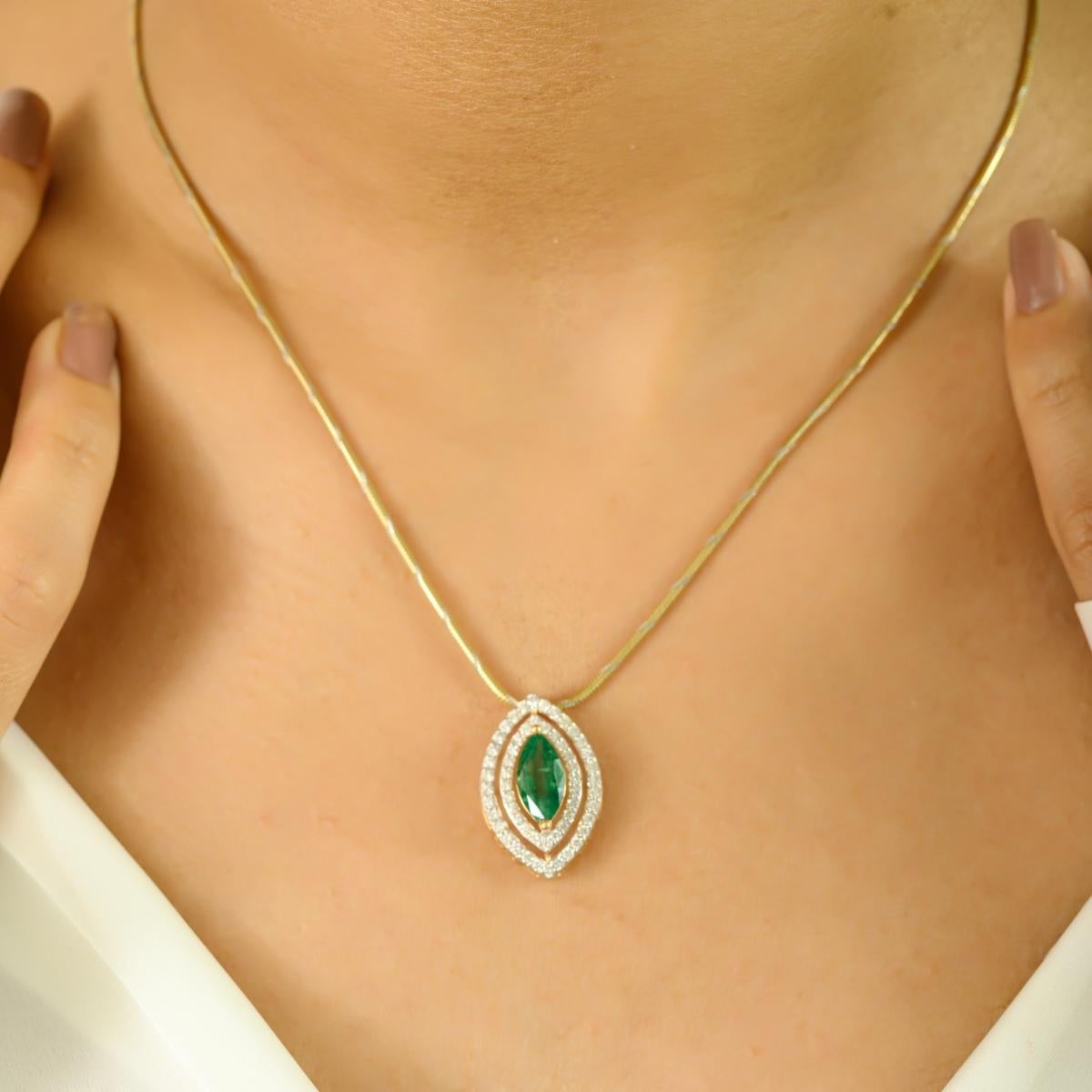 A stunning blend of elegance and brilliance, this pendant showcases a captivating 1.50 carat marquise-cut emerald at its center. Framed by double halos of sparkling diamonds totaling 0.57 carats, the design radiates sophistication and charm. Crafted