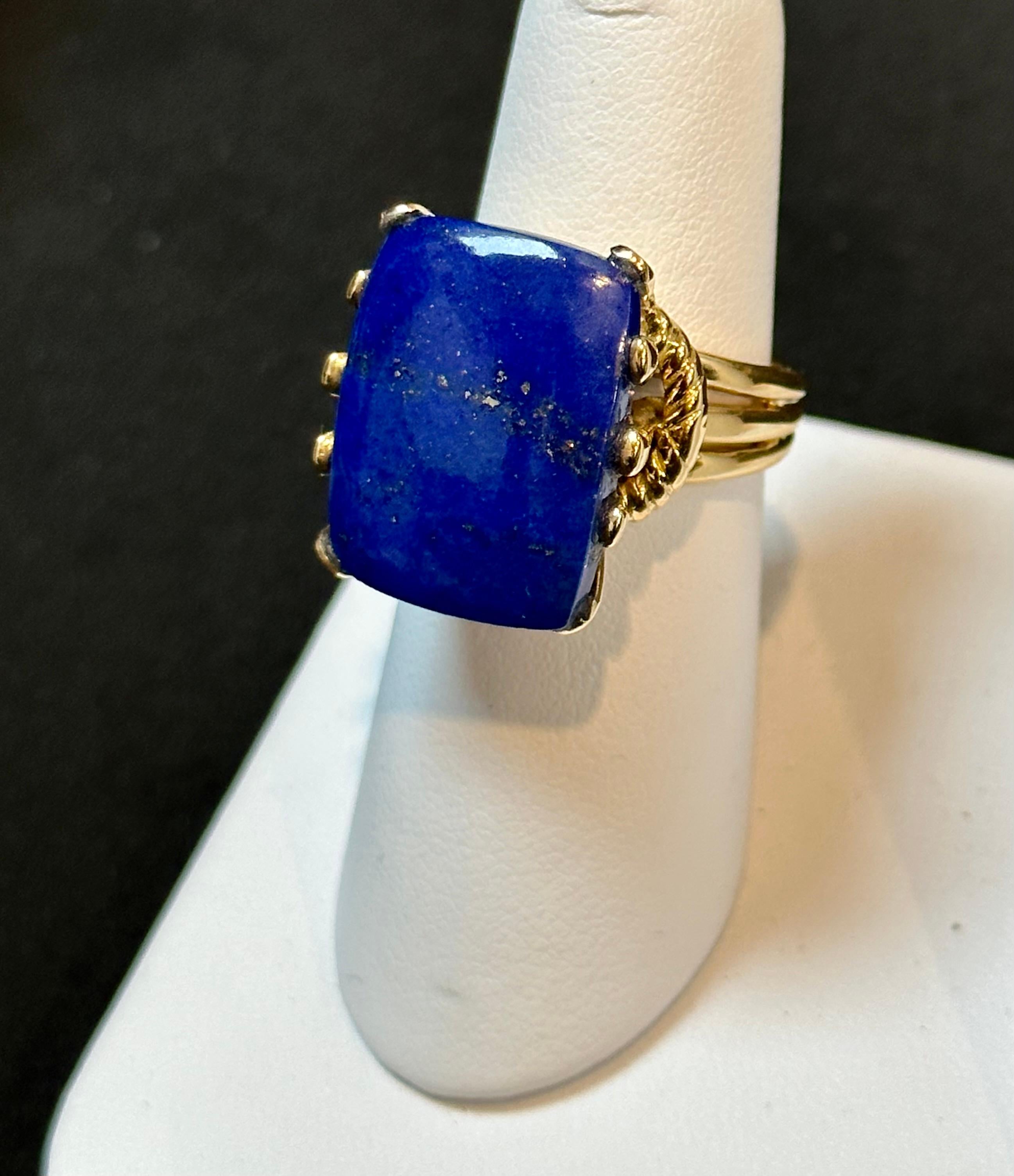 Introducing our exquisite Estate Lapis Lazuli Ring, crafted in 14 Karat Yellow Gold. This stunning ring features a magnificent 15 carat, high-quality, natural Lapis Lazuli gemstone in an Emerald cut shape. The color, cut, and clarity of the stone