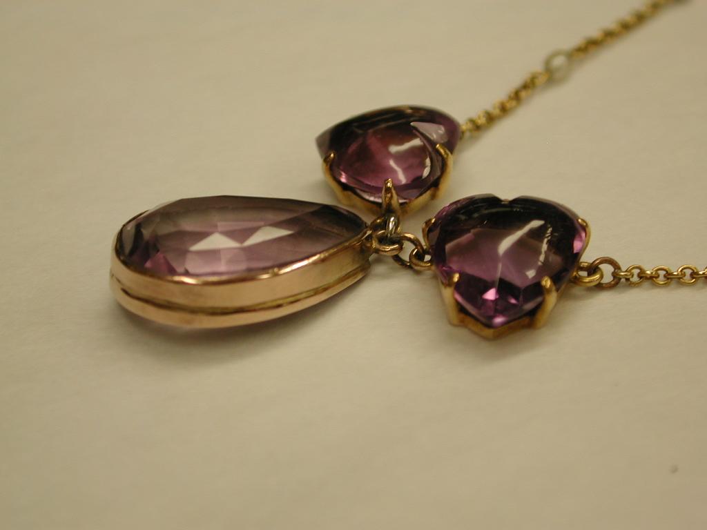 15 ct Gold Amethyst Pendant and Chain with Seed Pearls, 1910.
Bottom amethyst is pear shaped with two heart shaped amethysts either side.
The integral chain has seed pearls interspersed at equal interval either side.