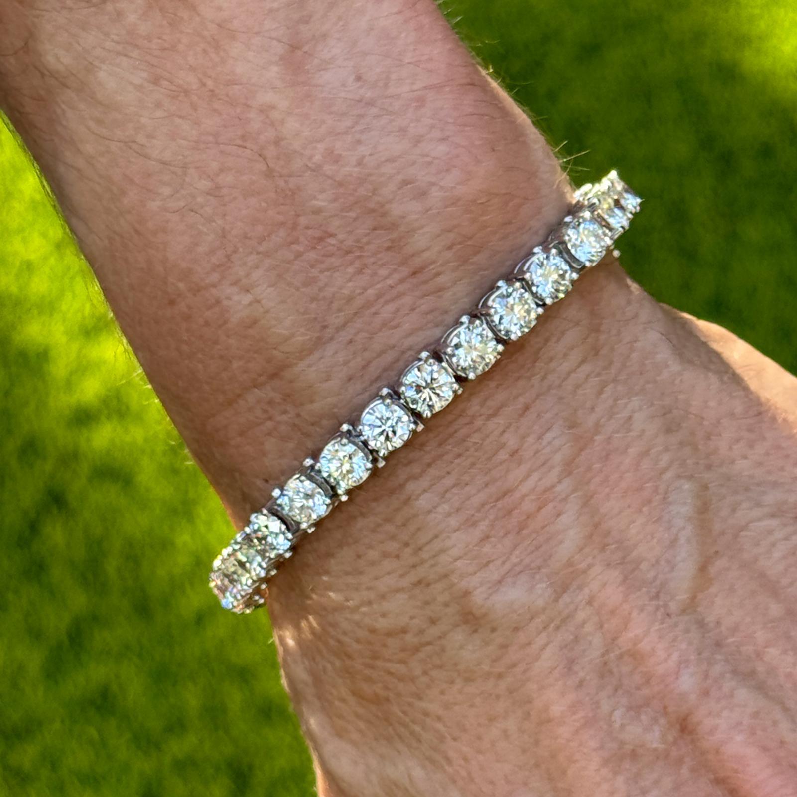 This exquisite 14 karat white gold diamond tennis bracelet showcases timeless elegance with 30 round brilliant-cut diamonds totaling approximately 15.00 carats, each averaging 0.50 carats. The diamonds, graded G-H color and SI clarity, are expertly