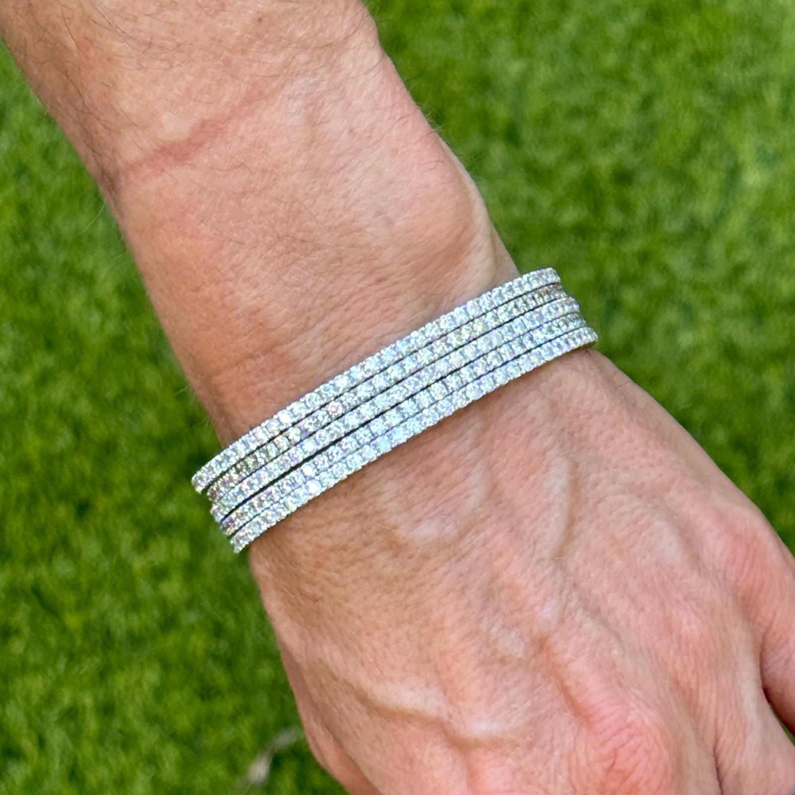 This elegant set of five diamond eternity bangles is crafted in 14k white gold and designed for effortless stacking or standalone wear. Each bangle is meticulously set with 79 round brilliant cut diamonds, totaling approximately 3.16 carats per