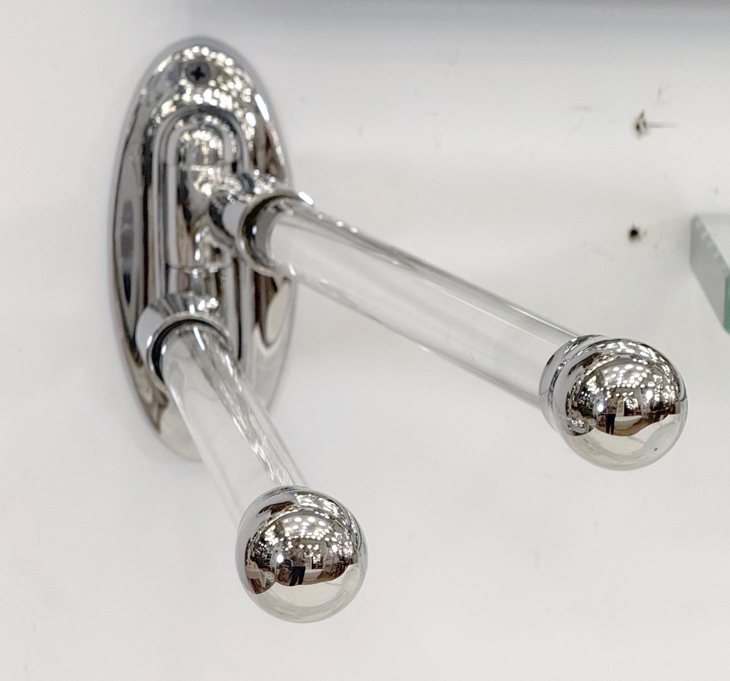 Swinging double arm wall mount towel rack. The bracket and rod ends are made of chromed brass and the rounded rods are made of clear glass. The original mounting screws are not available. Good condition with minor wear. One available. Please note,