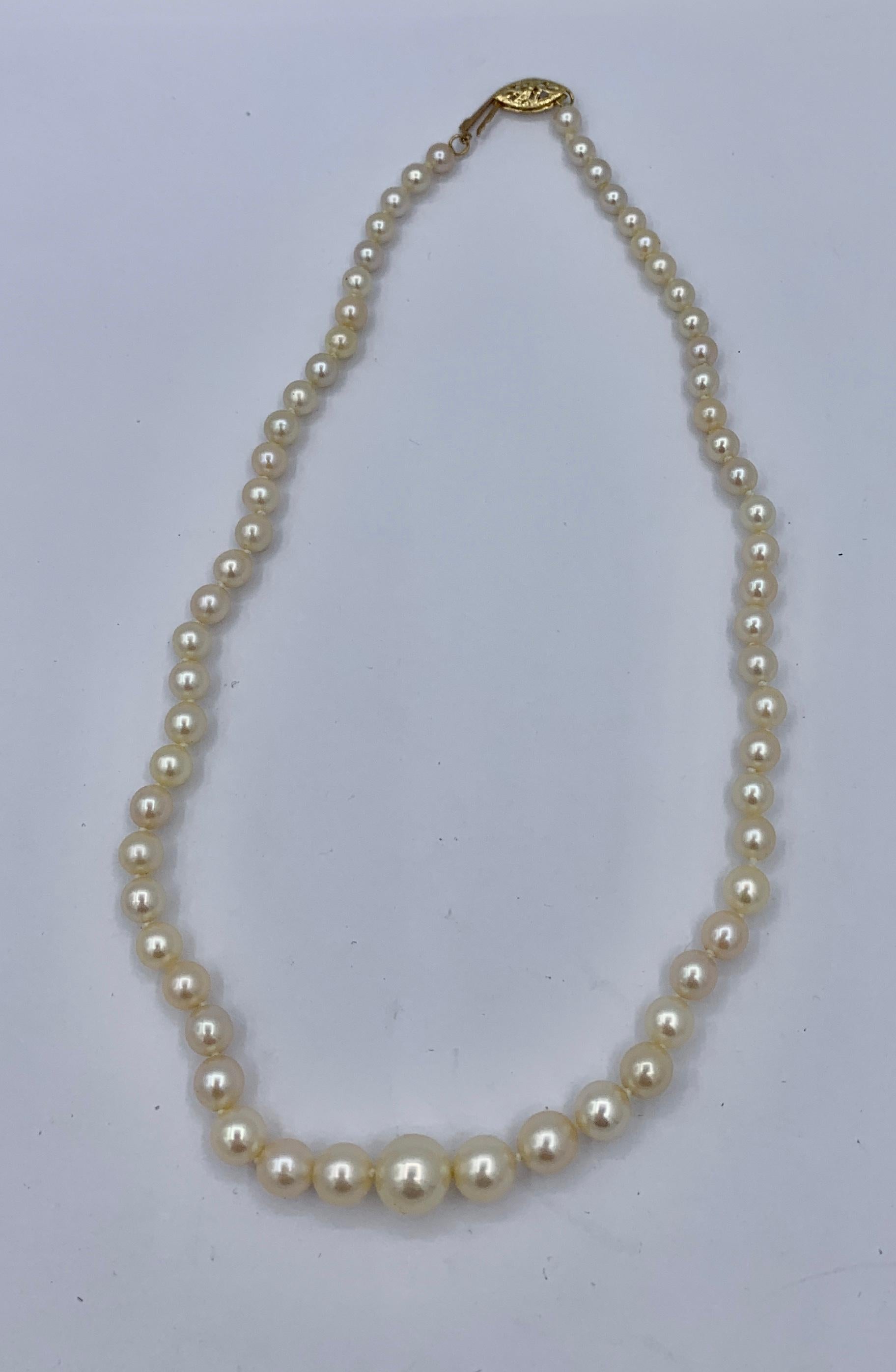 This is a beautiful 15 inch long Graduated Cultured Pearl Necklace with pearls graduated from 5mm to 10mm with a 14 Karat Yellow Gold clasp.   The pearls are beautiful silvery white pearls which are each individually knotted.  The stunning pearl