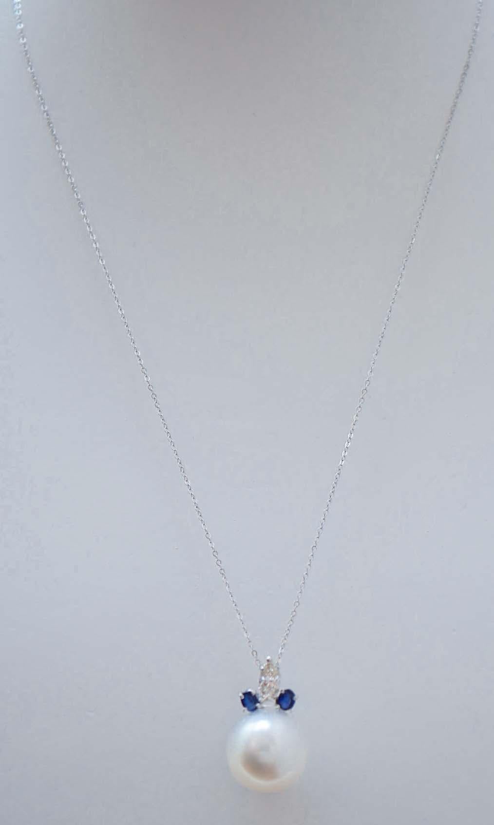 Incredibile ciondolo con struttura in platino montato con una perla e, su di essa, un'altra perla,  un diamante con due zaffiri. La catena in oro bianco 9 kt è inclusa.
Questo ciondolo è stato realizzato completamente a mano da maestri orafi