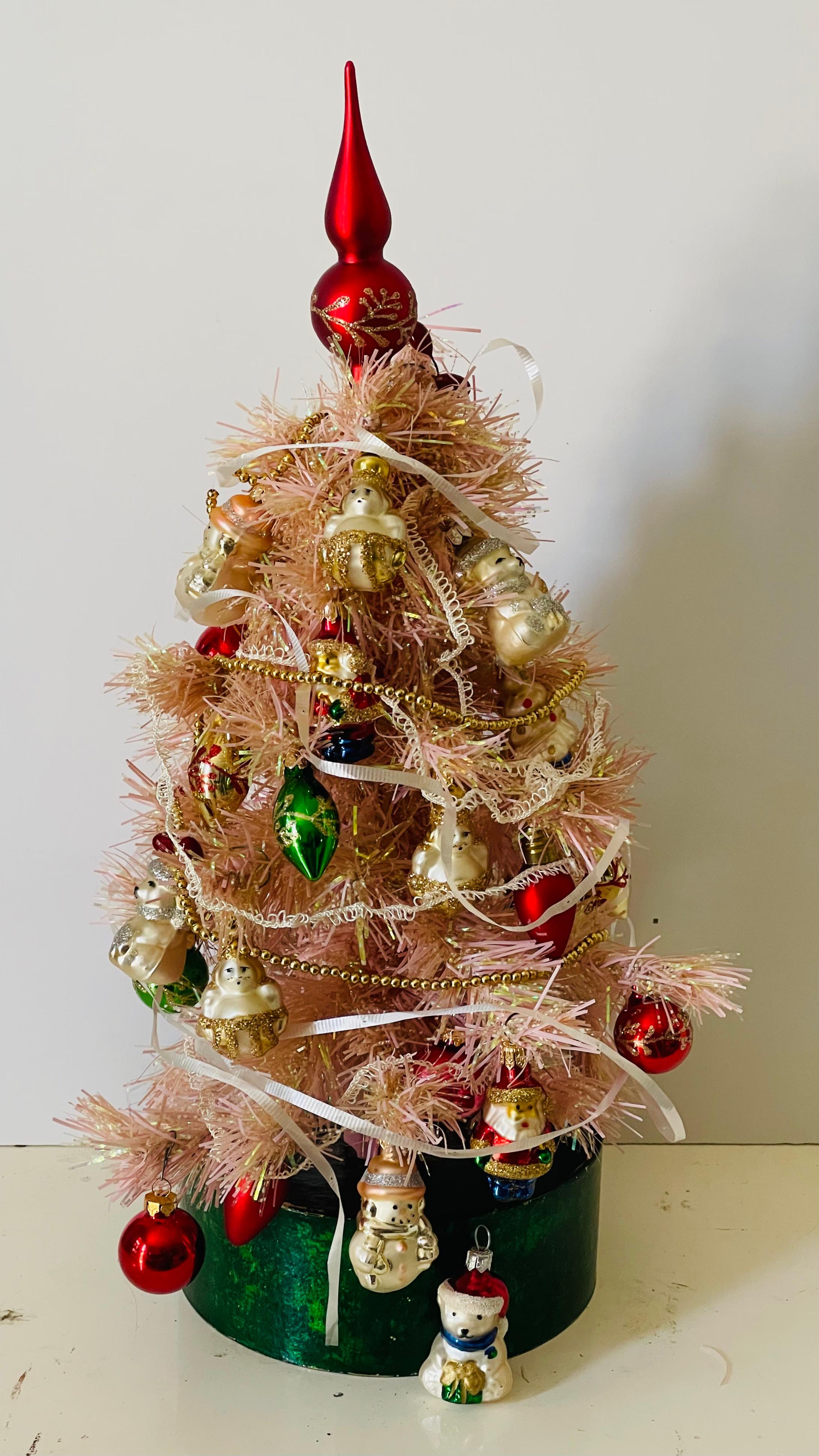 Cute small 15” pink Christmas trees decorated with miniature blown glass European Christmas ornaments and figurines. Blown glass tree topper, gold mini garland.